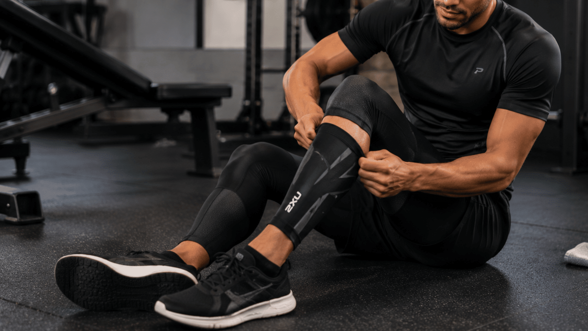 athlete wearing compression gear on legs during recovery and training session in a modern gym