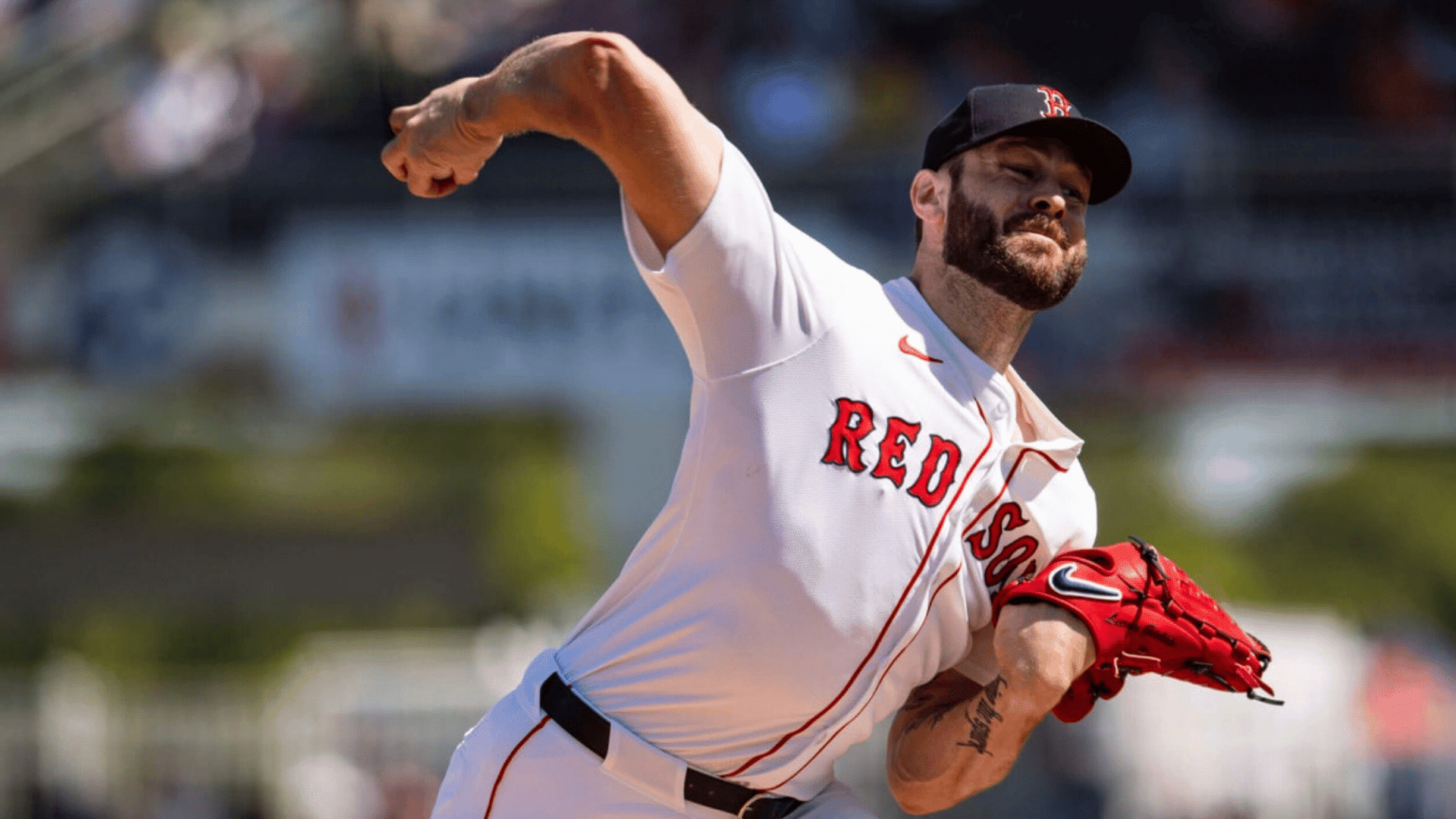 baseball pitcher throwing a pitch during a game wearing a white red sox uniform and red glove