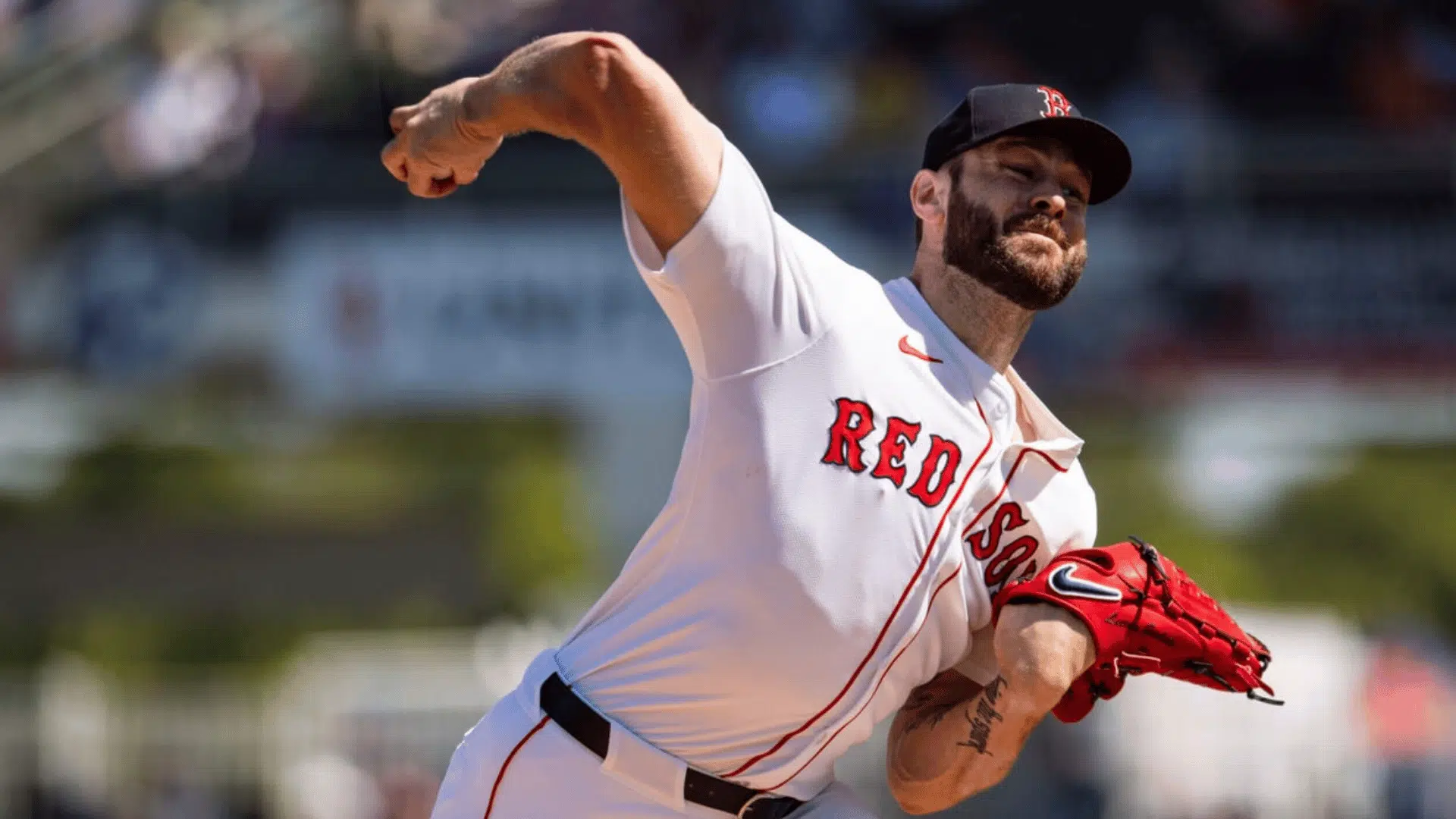 baseball pitcher throwing a pitch during a game wearing a white red sox uniform and red glove