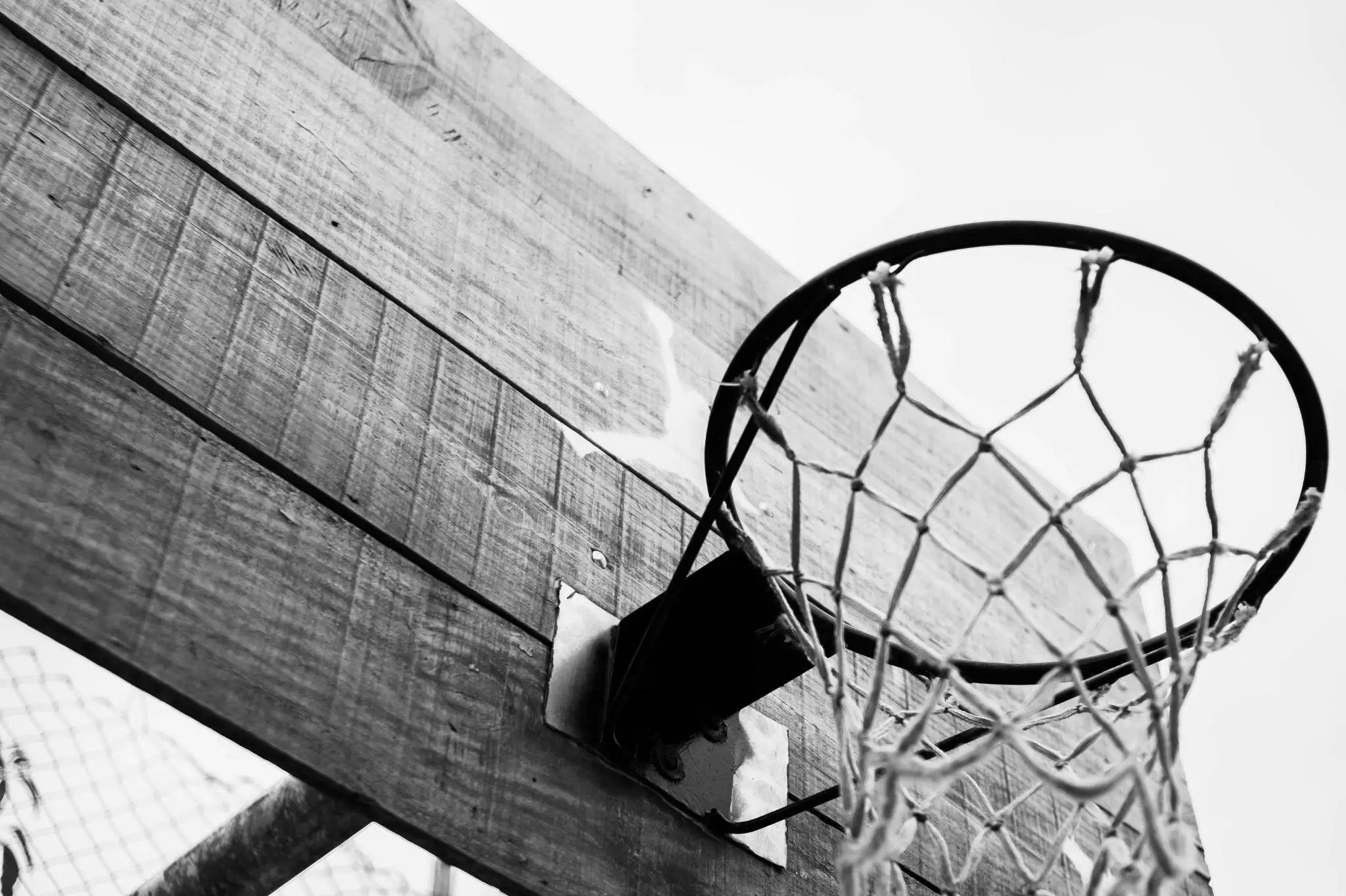 Black and white shot of wooden basketball hoop against clear sky