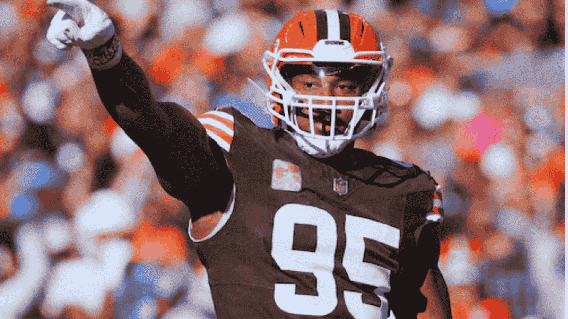 browns defensive player myles garrett wearing number 95 points downfield during a break in play
