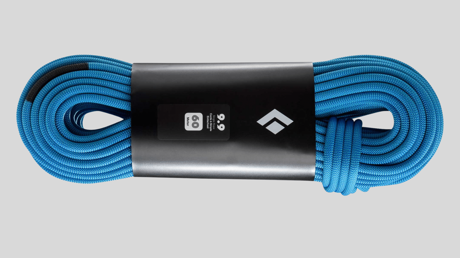 coiled blue climbing rope with protective sleeve and label for outdoor climbing use on a clean background