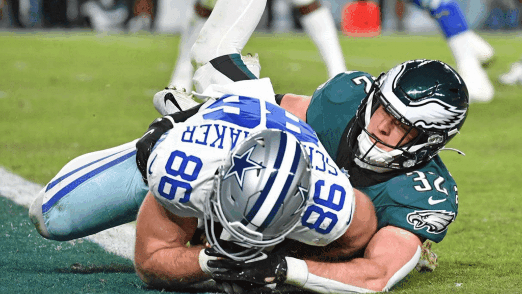 football player in green jersey tackles opposing player near the goal line during an intense game moment