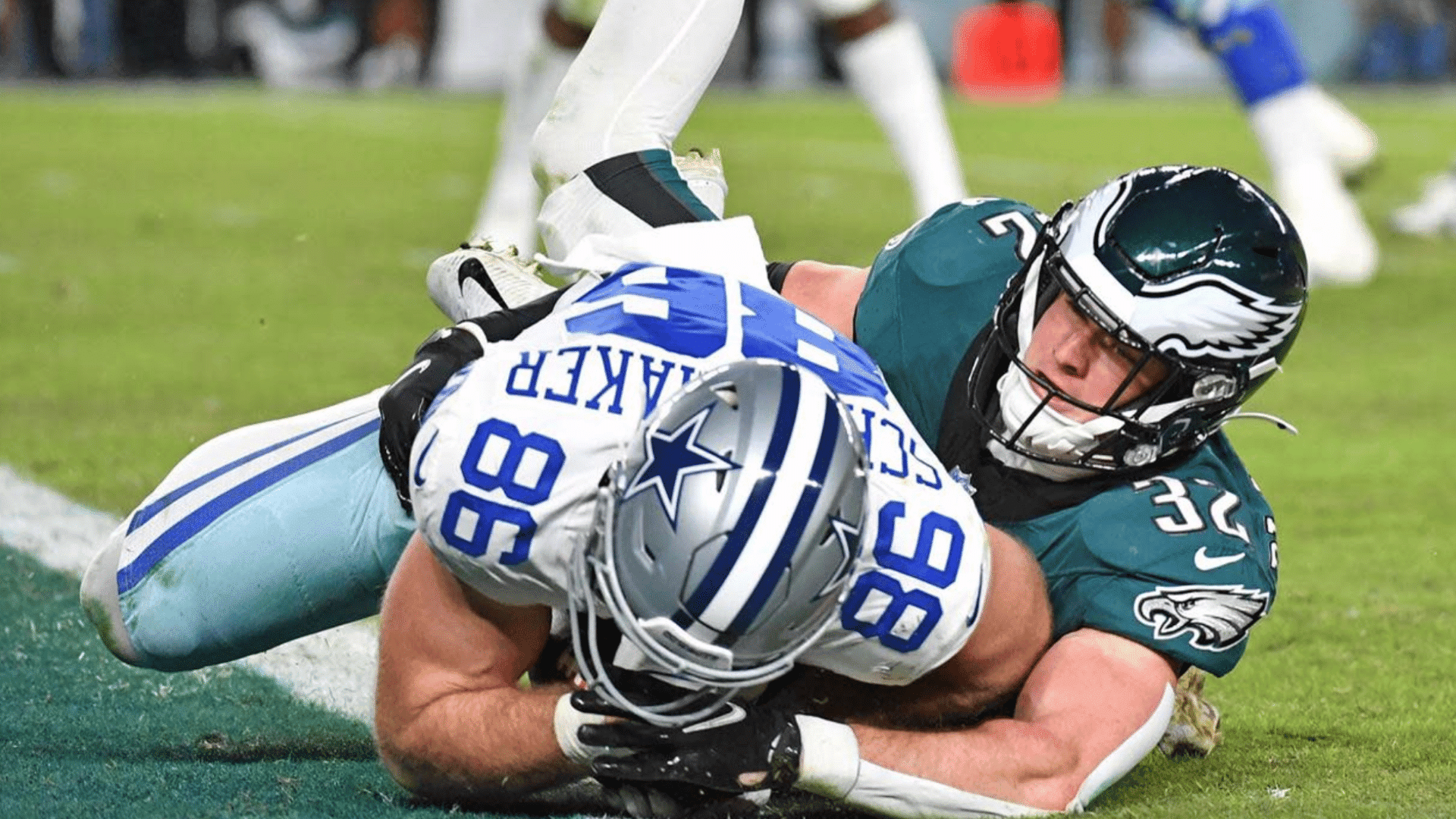 football player in green jersey tackles opposing player near the goal line during an intense game moment