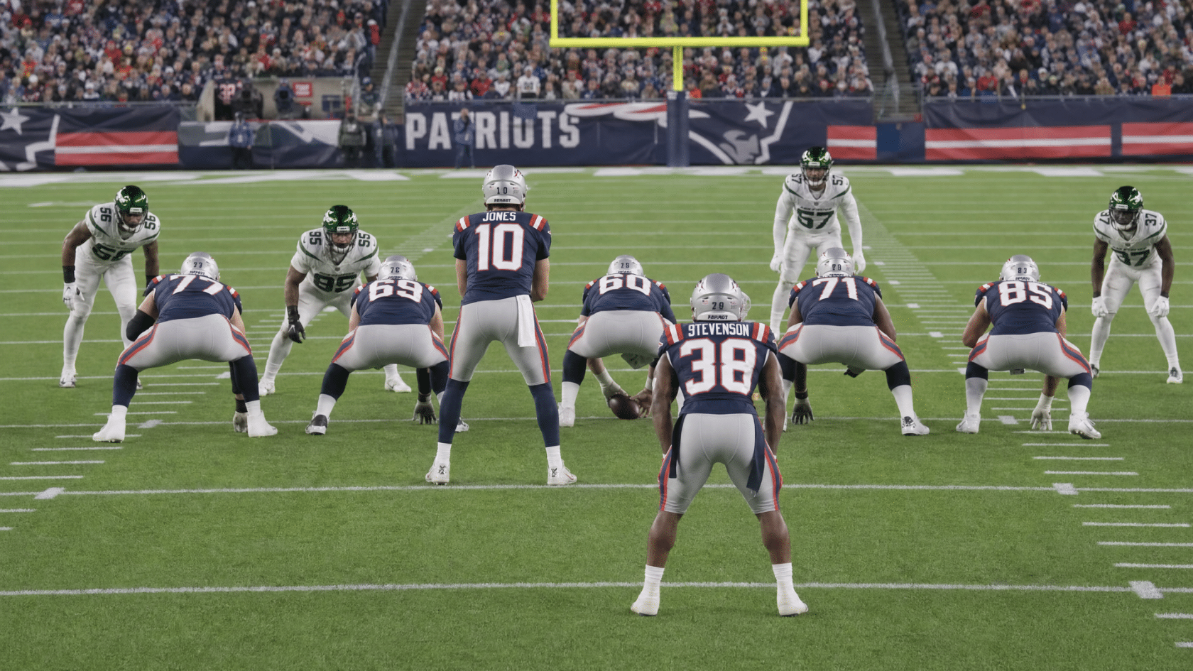 football players lined up at the line of scrimmage before a play during a professional stadium game matchup