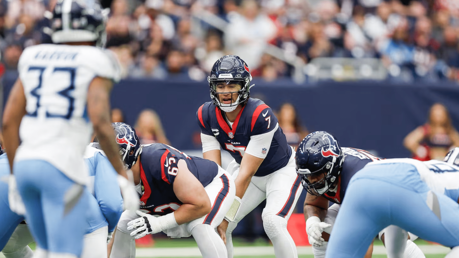 football quarterback prepares for the snap while opposing players line up during a professional stadium game
