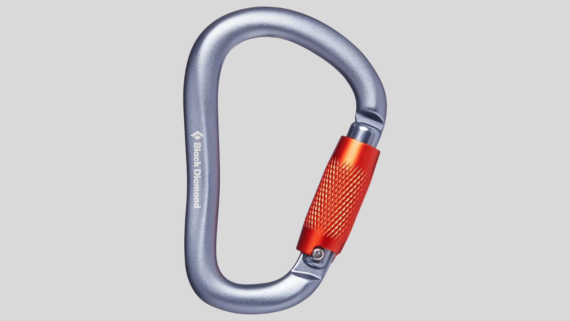 gray carabiner with orange screw gate used for climbing and safety gear on a plain background