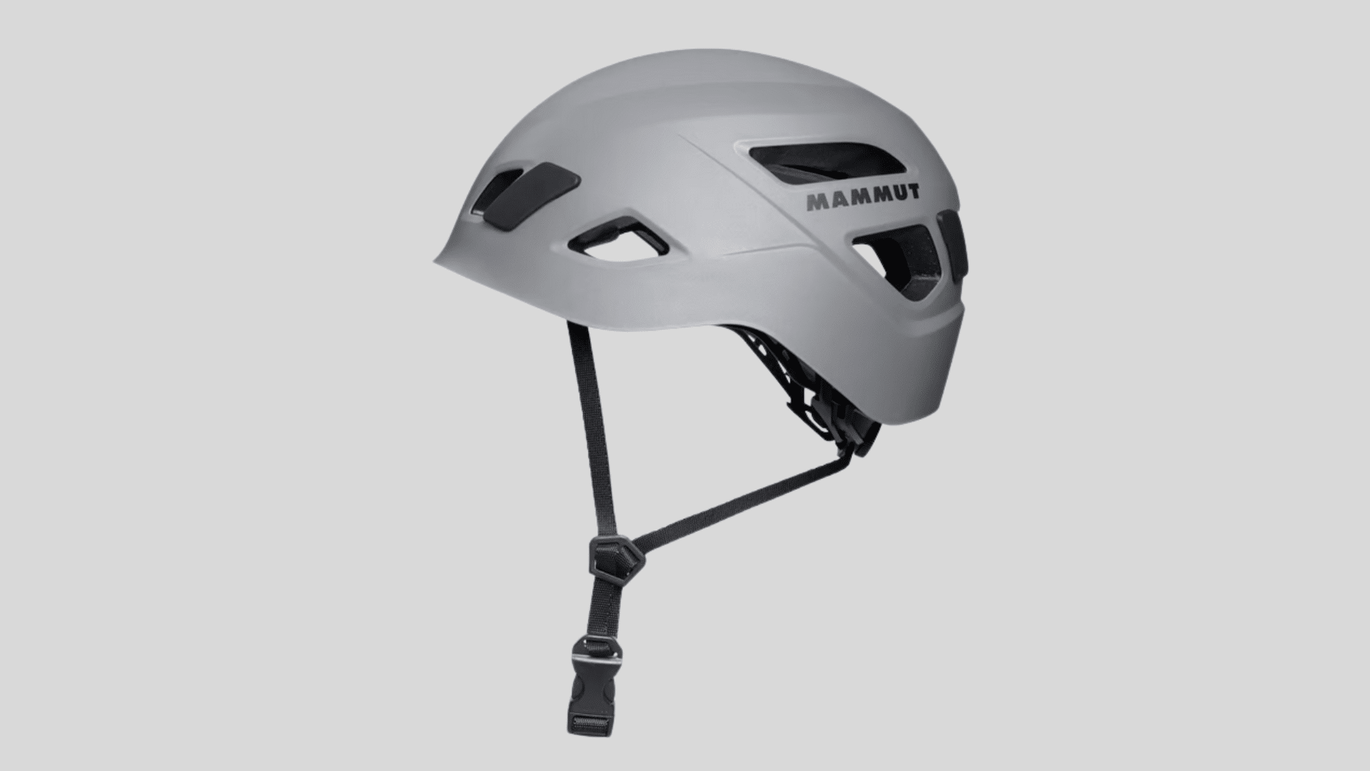 gray climbing helmet with ventilation openings and adjustable chin strap for safety use on a clean background