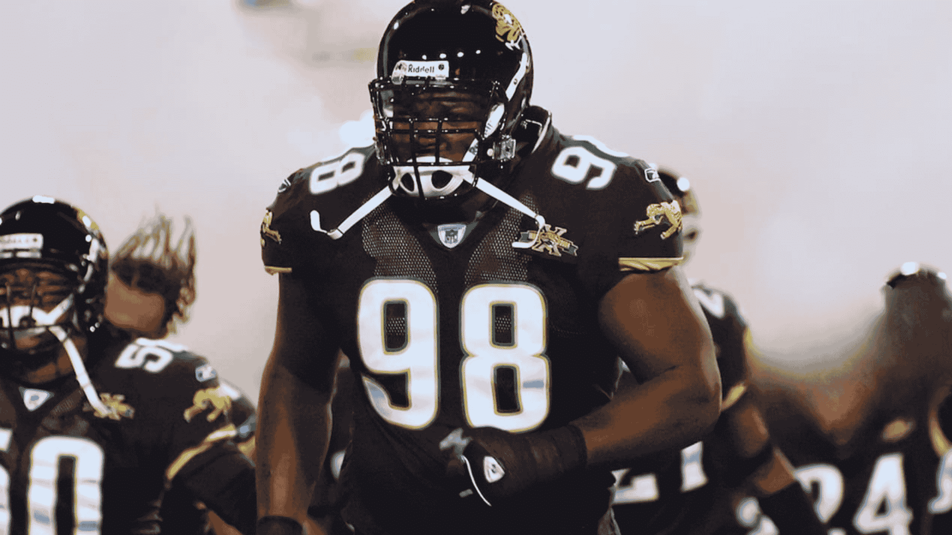 john henderson number 98 in black jaguars uniform charging onto the field with teammates