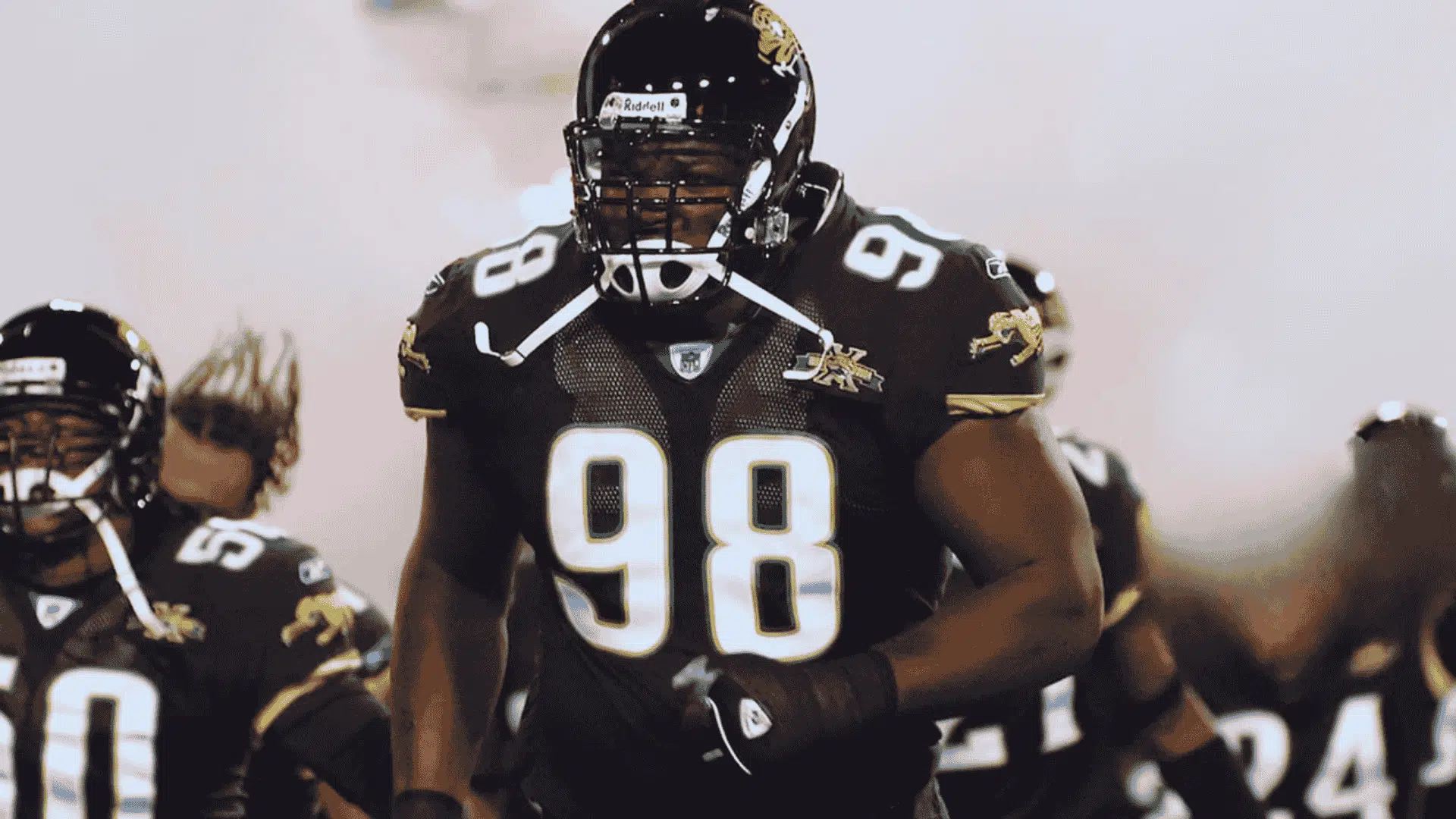 john henderson number 98 in black jaguars uniform charging onto the field with teammates