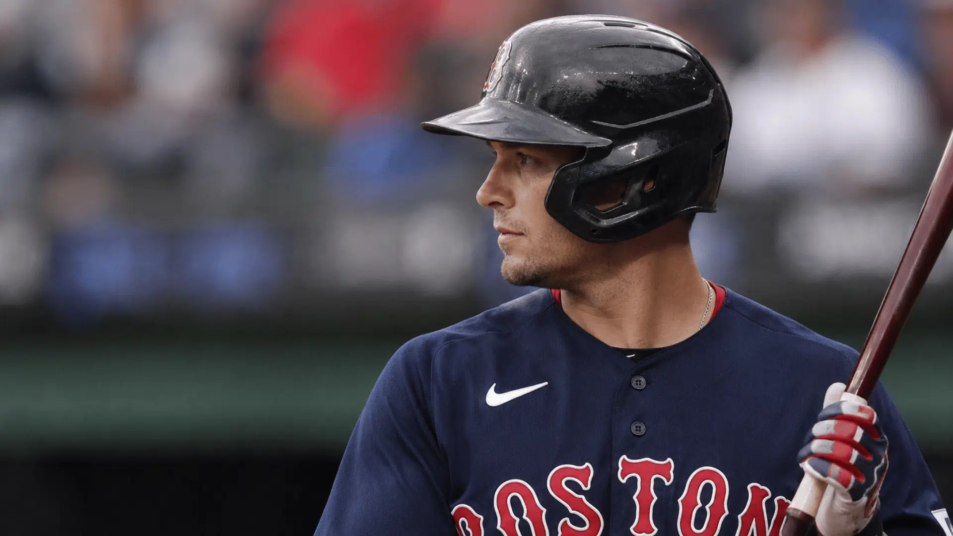 realistic baseball player wearing black helmet and holding bat with blurred stadium crowd in background