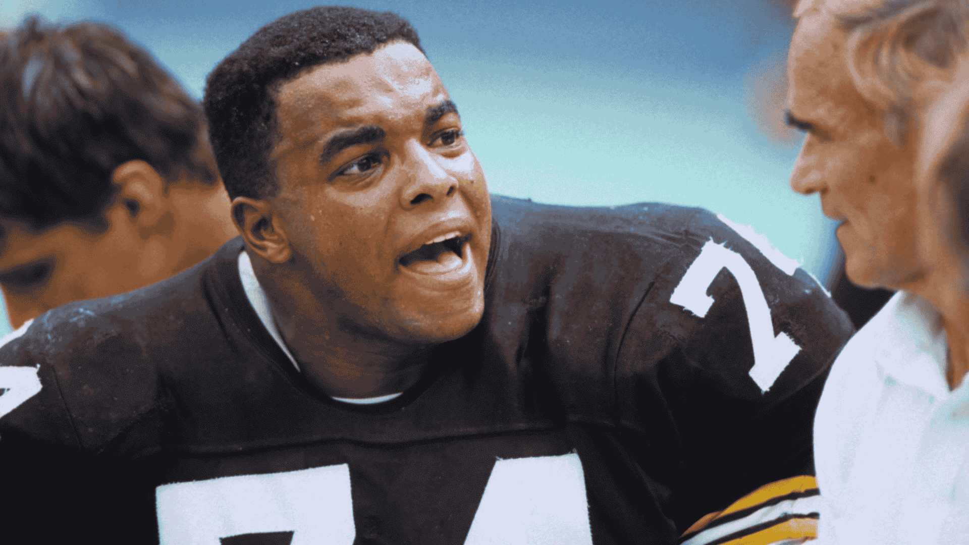 vintage football player terry long wearing number 74 shouts toward a teammate during a sideline moment