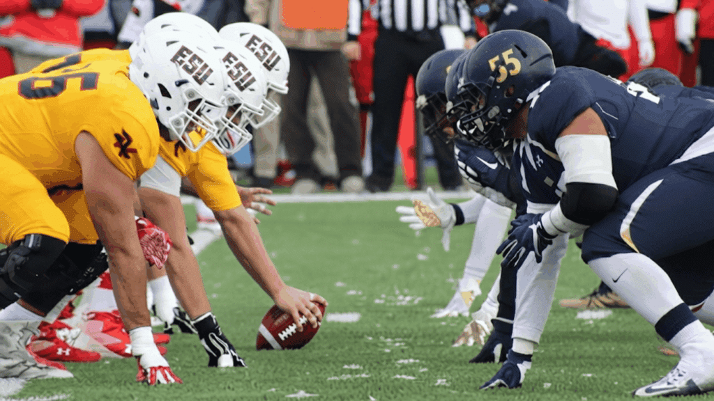 football players lined up before a play on the field during a competitive game action
