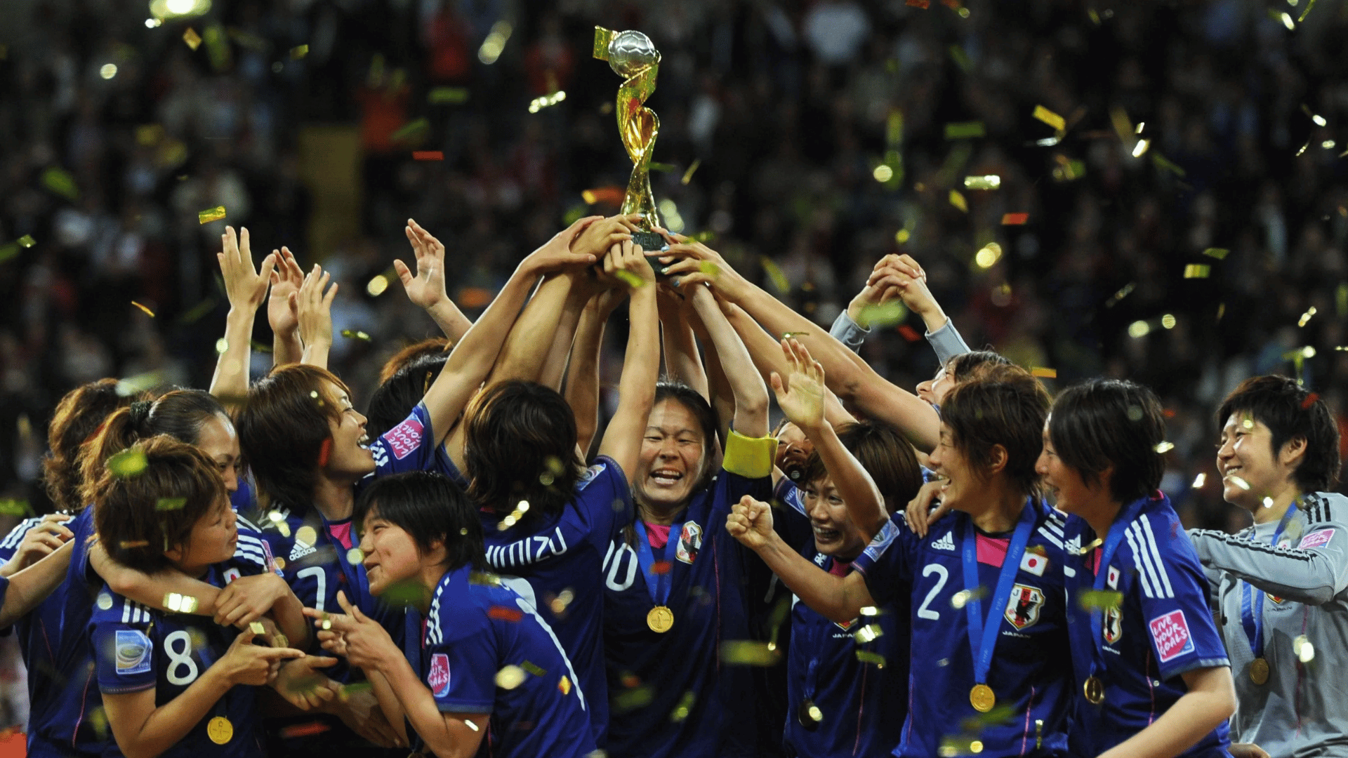 japan womens soccer players celebrate together with joyful hugs after scoring during an international tournament match