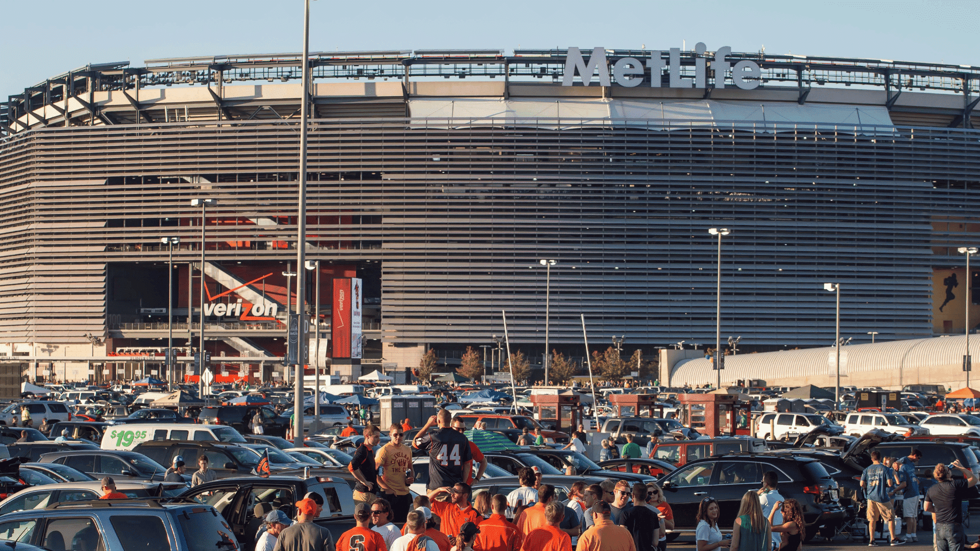 large crowd of sports fans gathering and tailgating outside the metlife stadium exterior