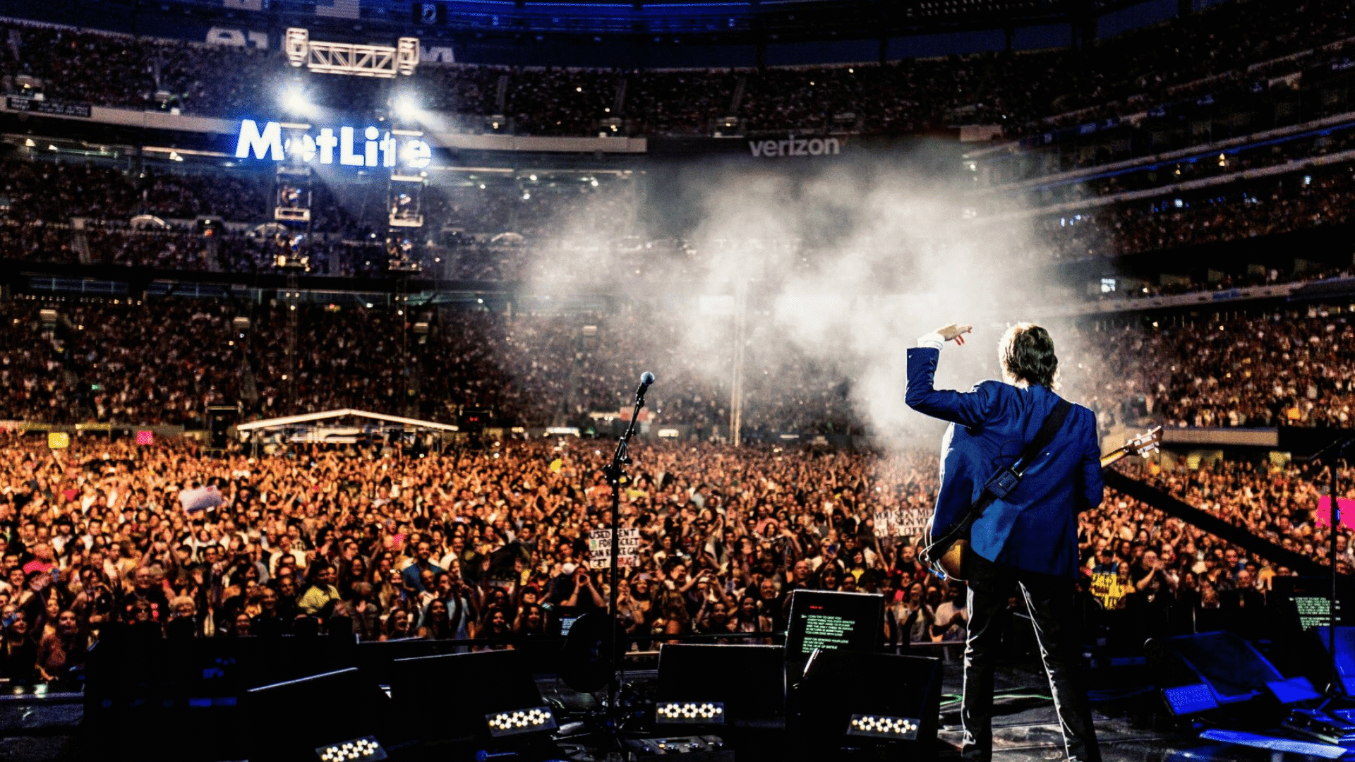 live stadium concert performance showing a musician playing guitar for a massive crowd