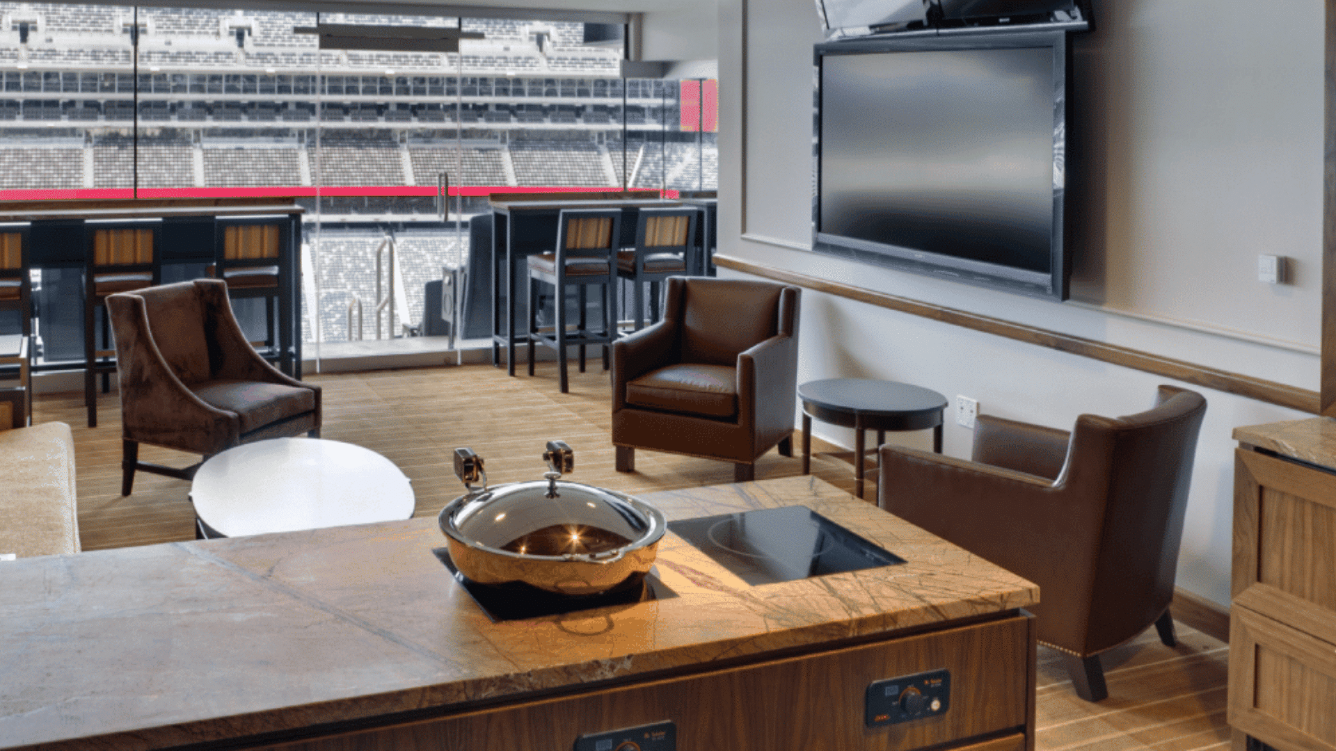 luxurious private stadium suite featuring leather armchairs television and serving area