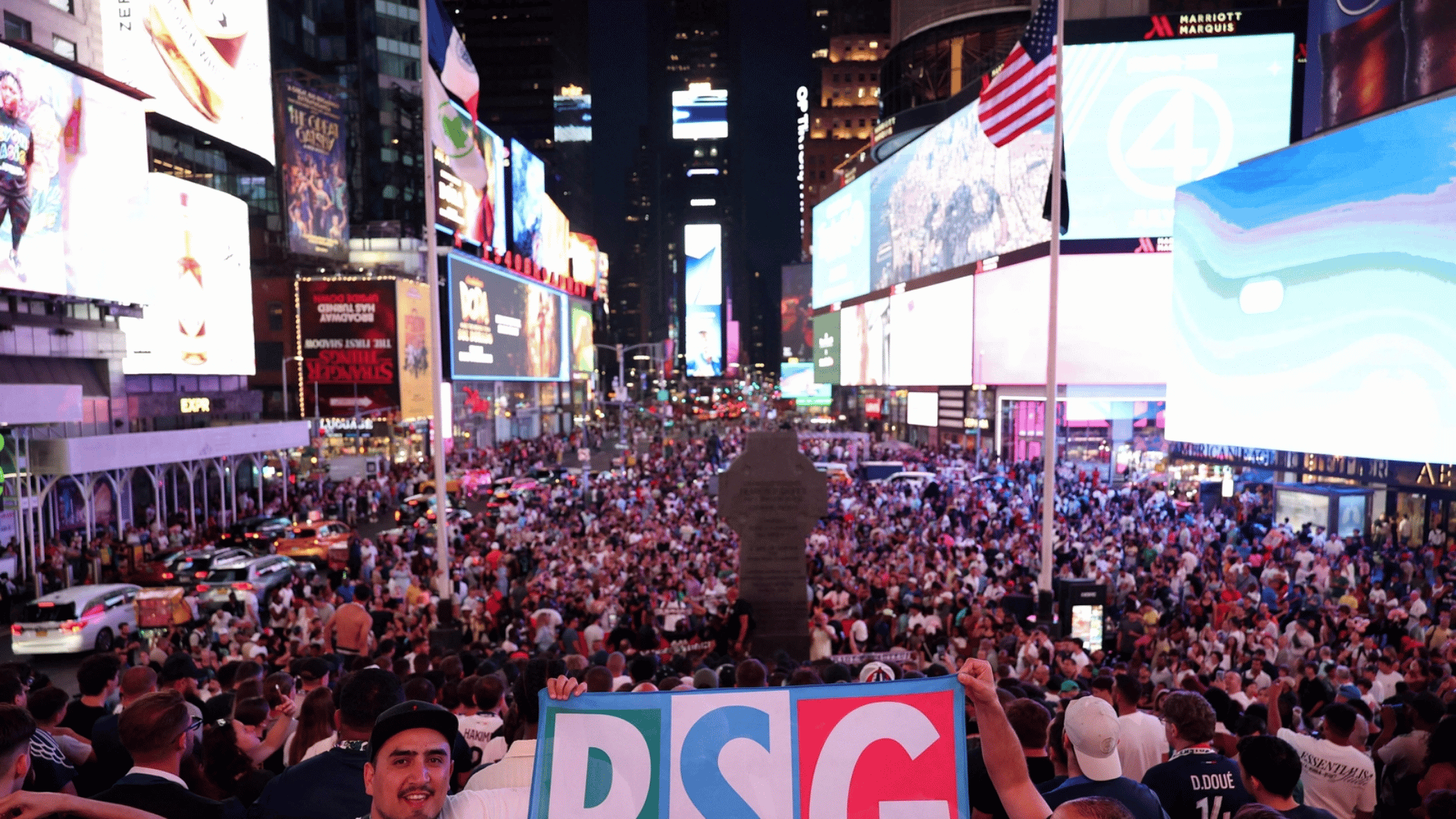 massive energetic crowd gathered outdoors in times square surrounded by bright billboards