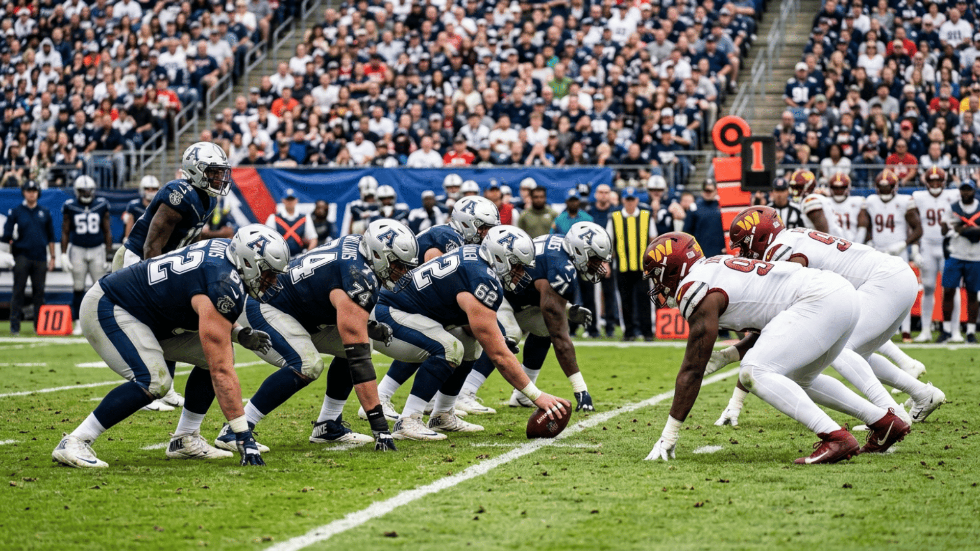 offensive and defensive football linemen lined up before a play on the field with stadium crowd background