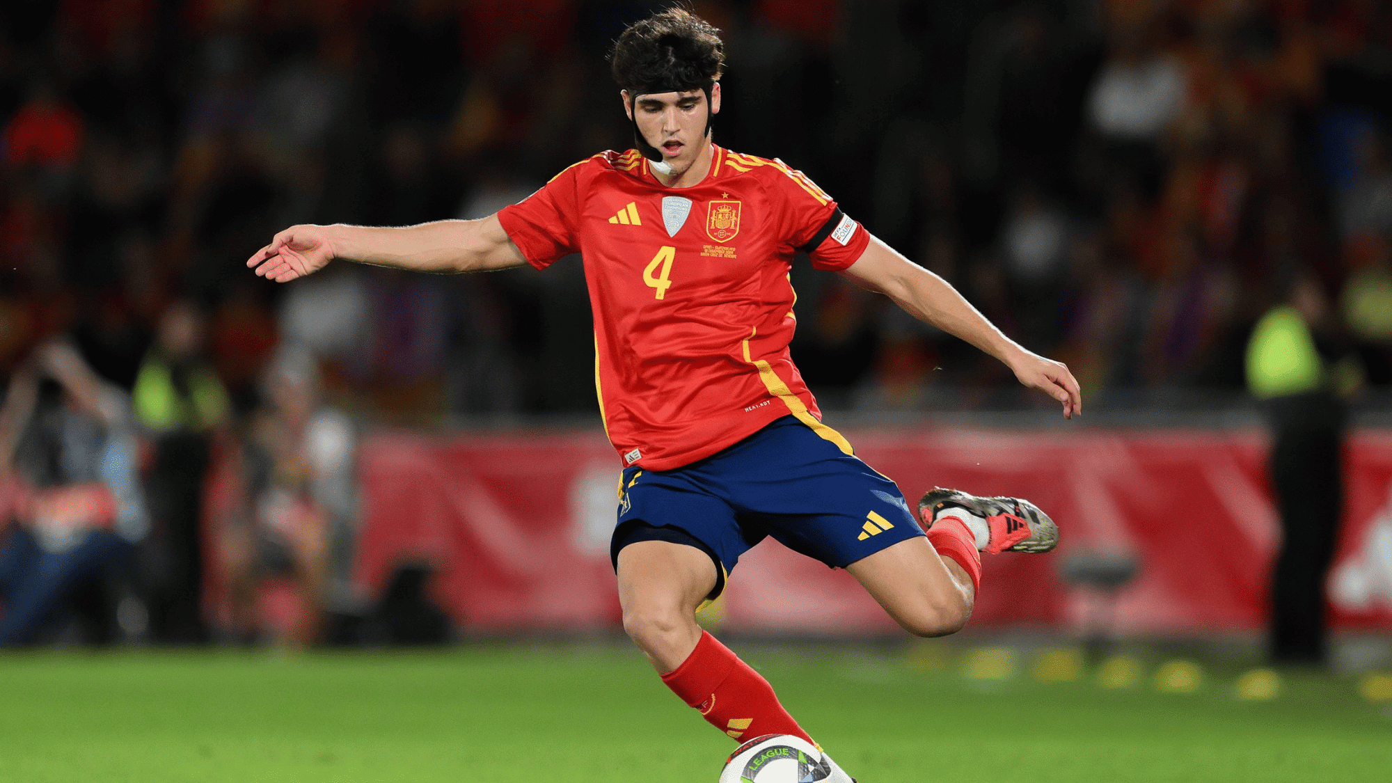 pau cubarsi kicking the football during an international match for spain while wearing the national team kit