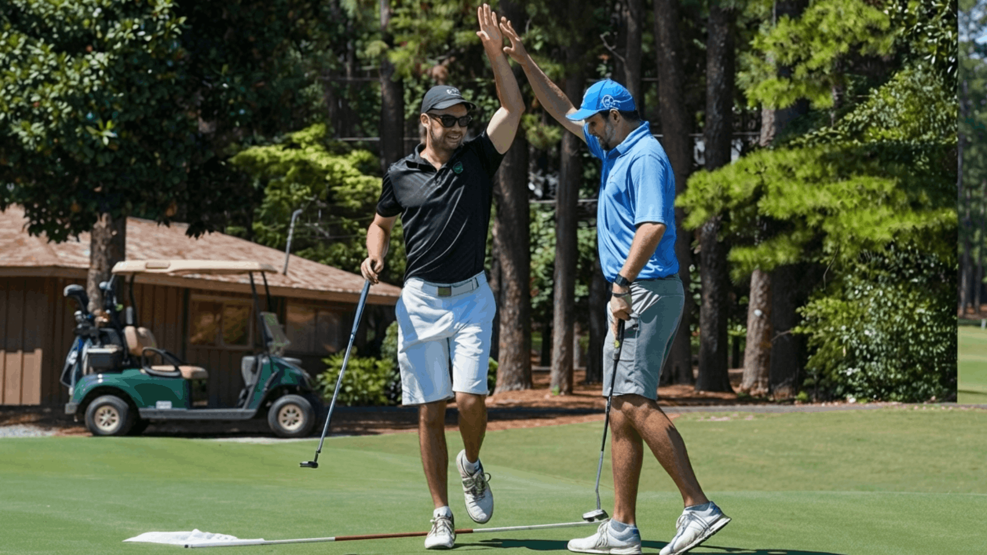 two golfers celebrating on a green course with golf clubs and trees in the background during a sunny day