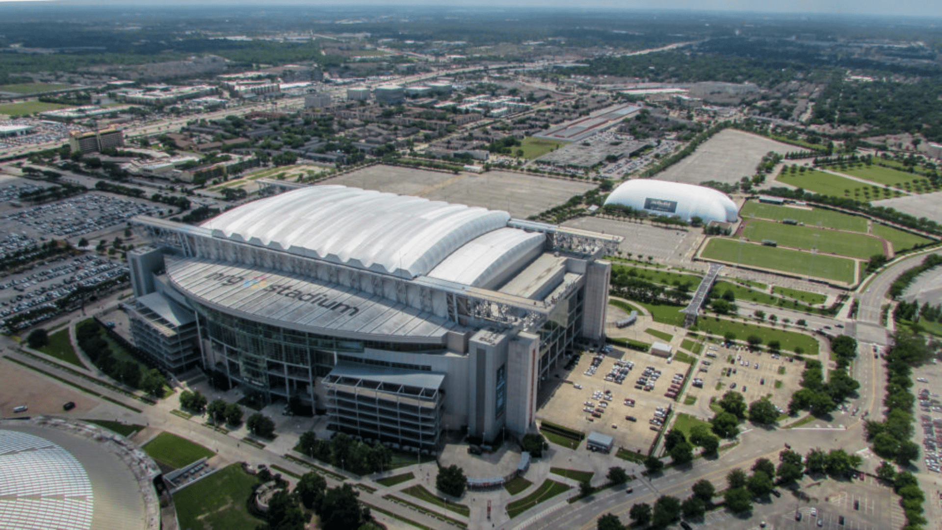 view of houston nrg stadium surrounded by parking lots roads and green spaces