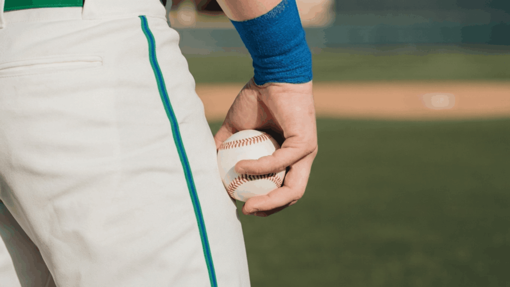 a baseball player holding a baseball behind the hip with a pitching grip while standing on the field ready to begin a throw (1)