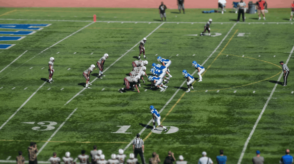 american football teams lined up before the snap showing offensive and defensive formations on the field