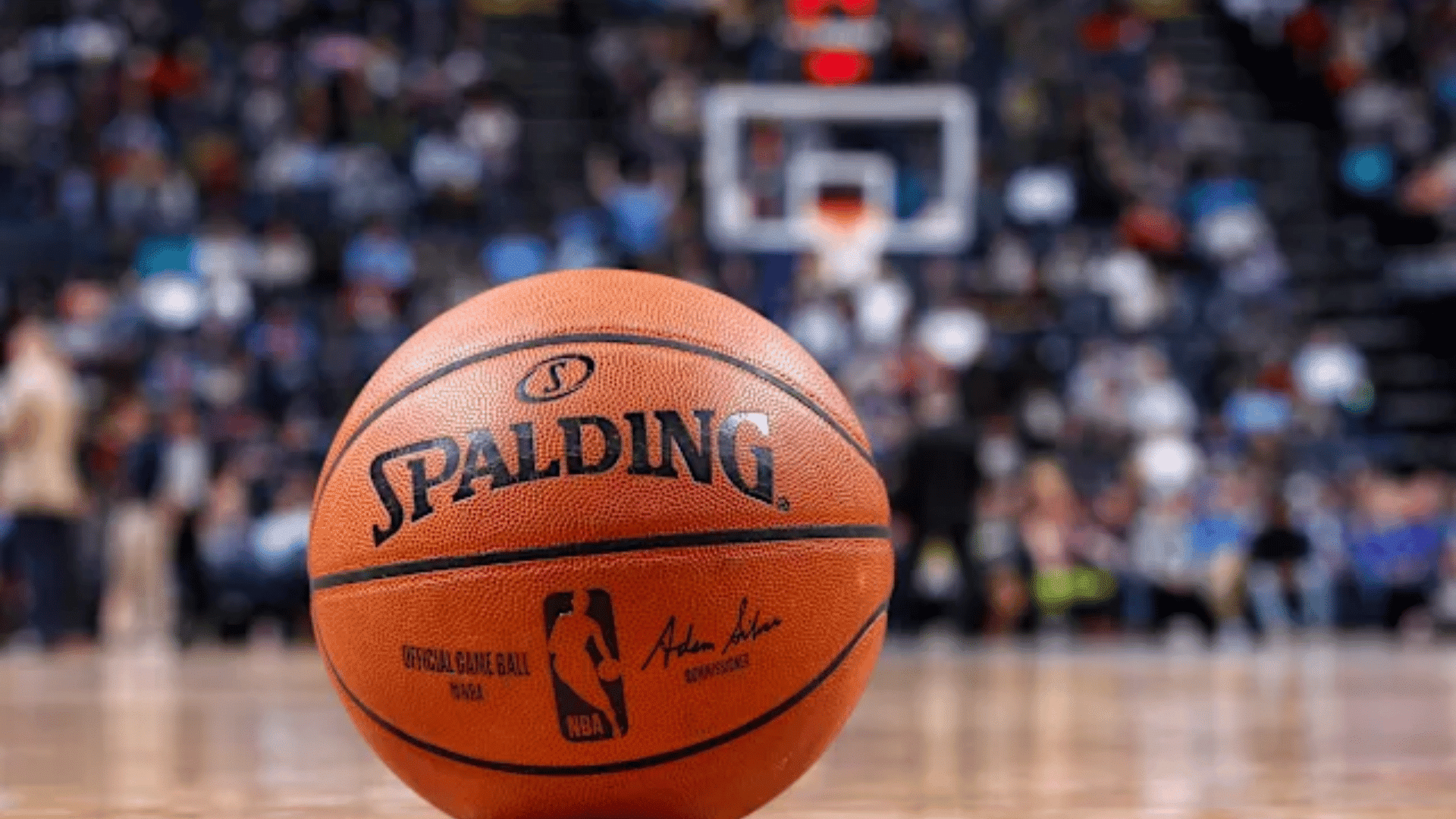 basketball player dribbling past a defender during an nba game with the crowd filling the arena behind the court (1)