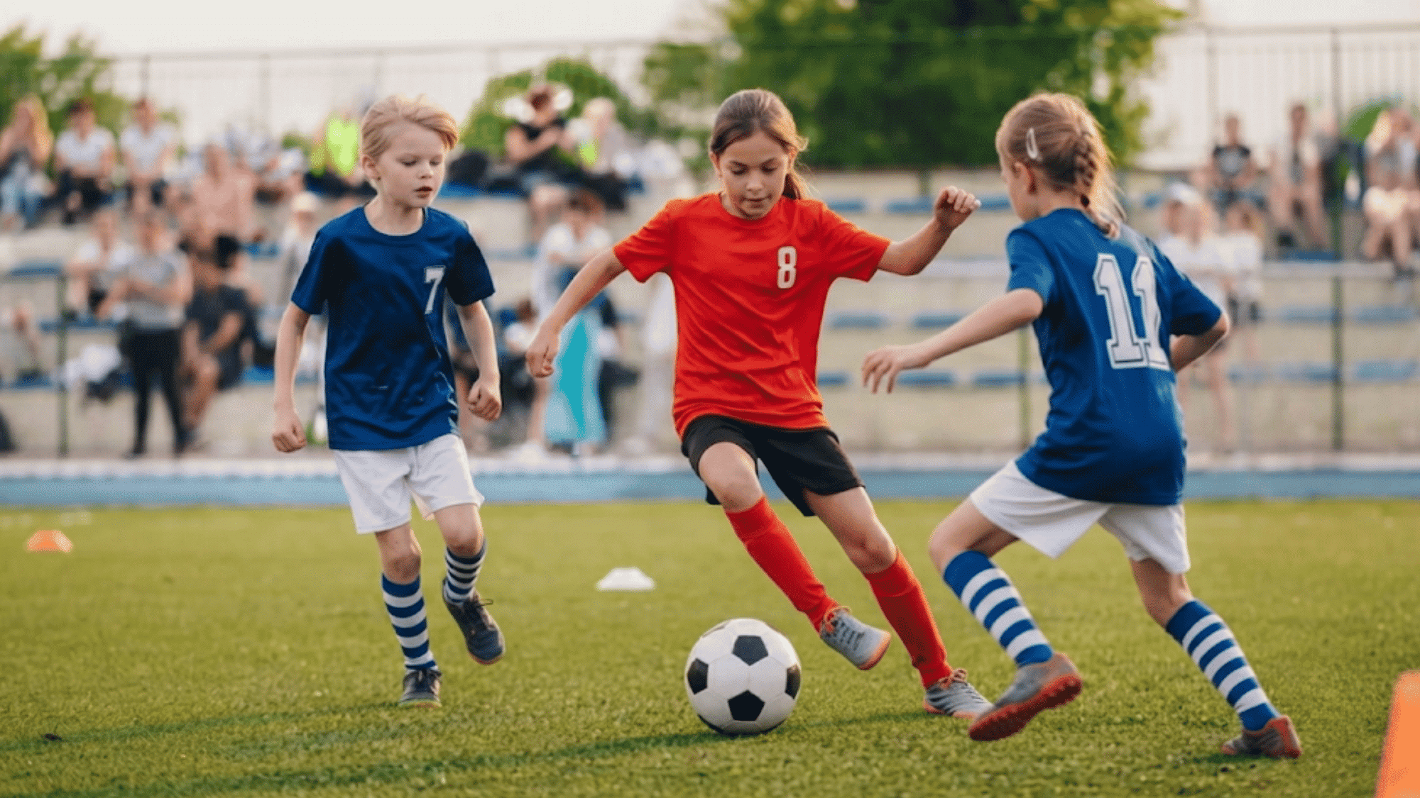 children playing soccer match on a field with players competing for the ball during an outdoor game