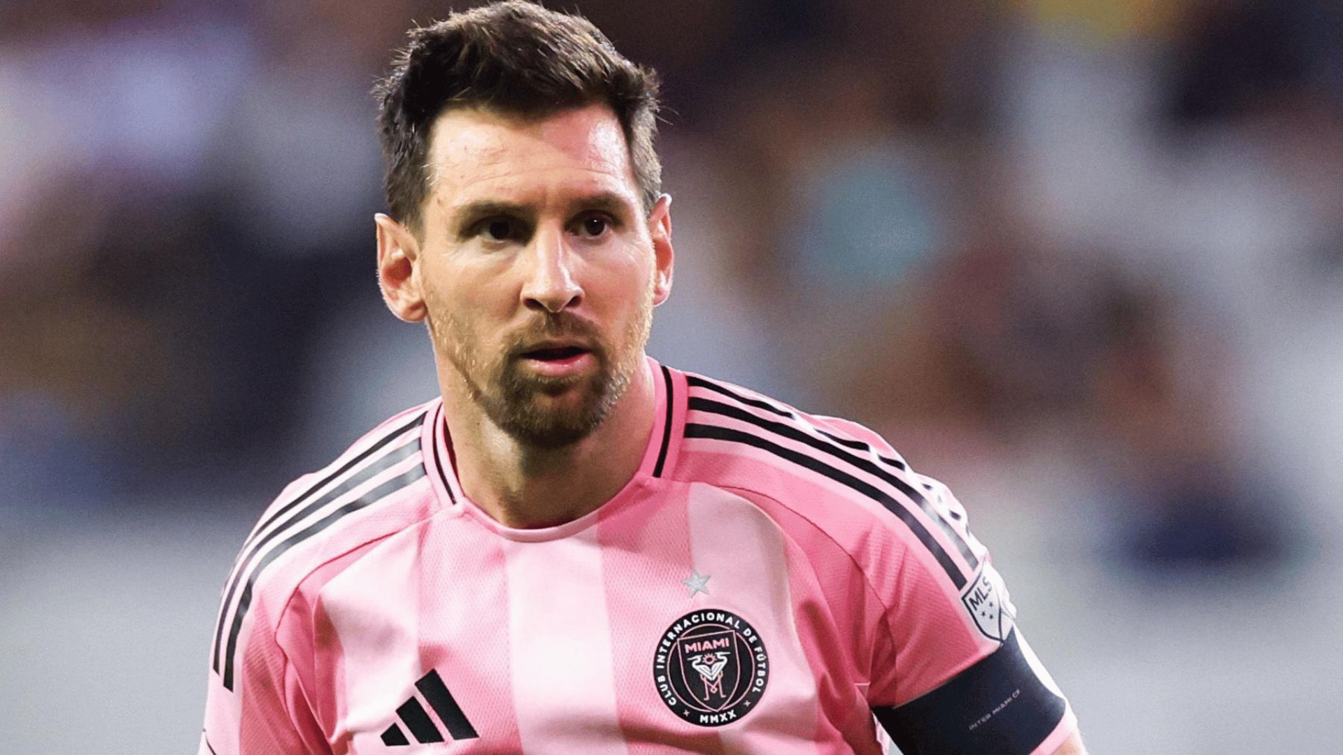 lionel messi wearing a pink club jersey standing on the field during a stadium match