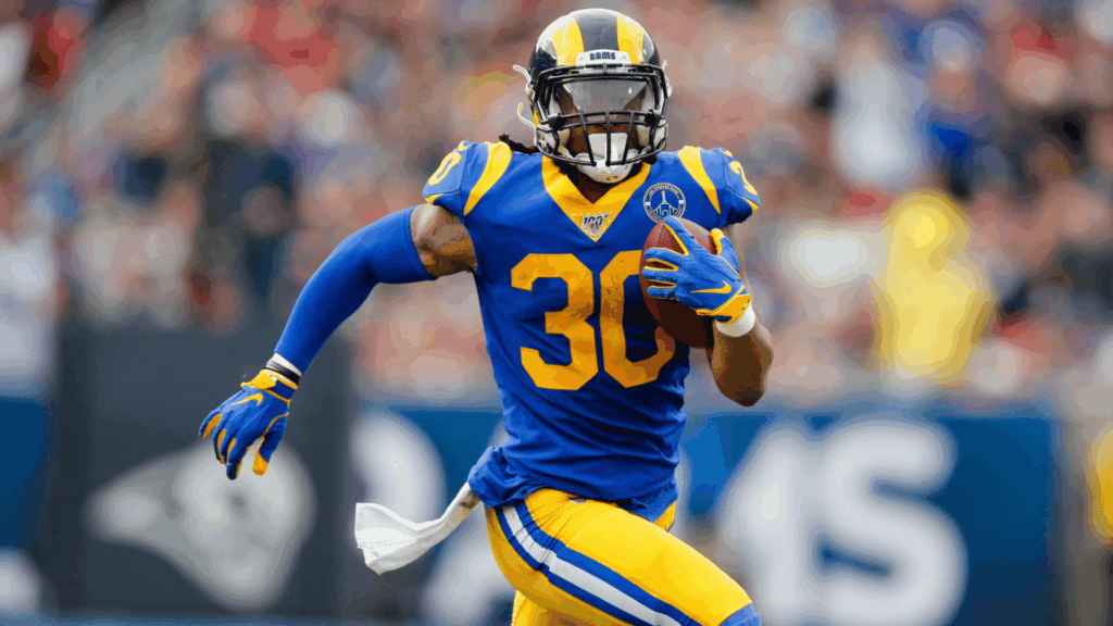 running back carries the football upfield during a game while sprinting in a los angeles rams uniform (2)