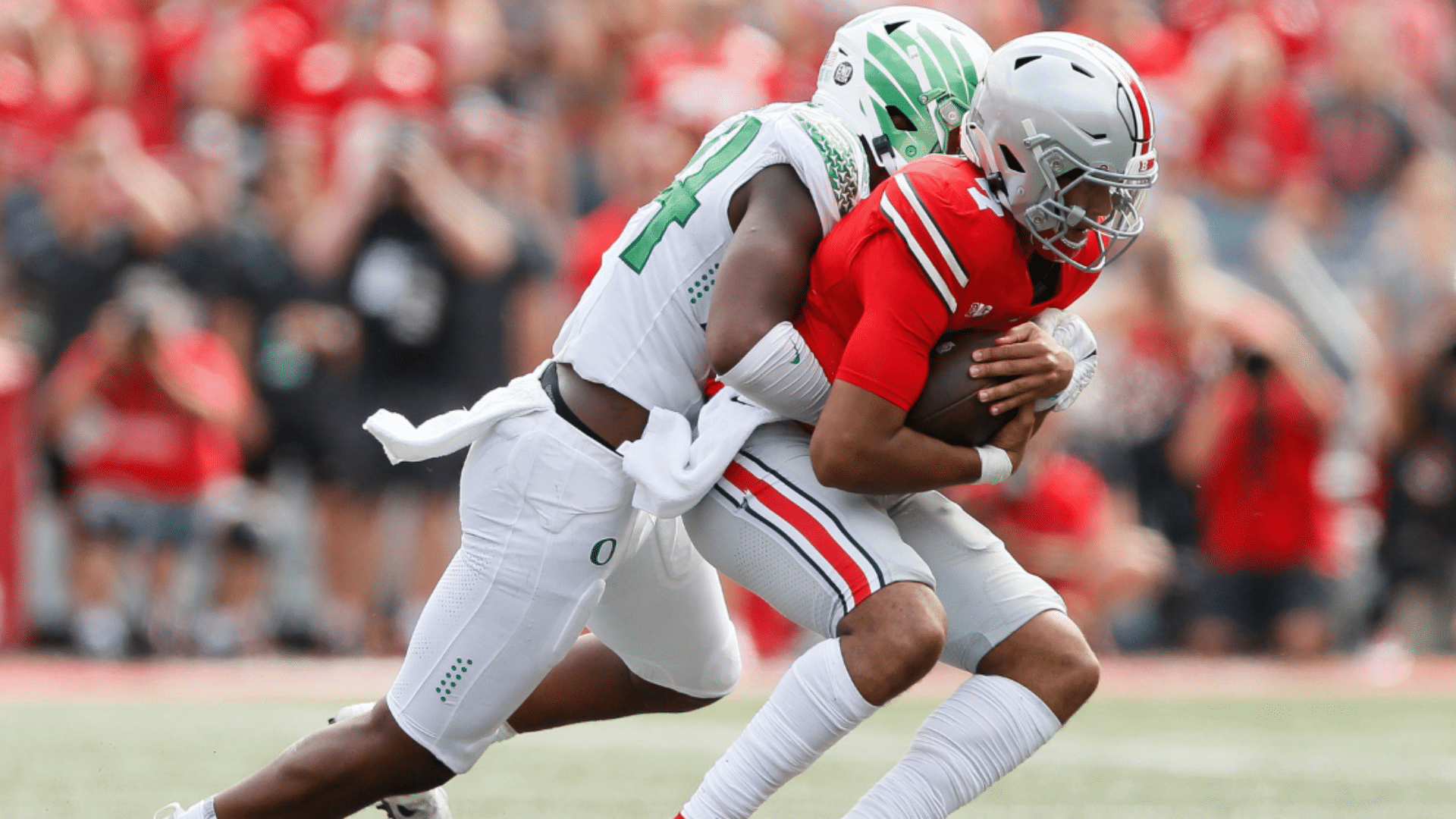 rusher wraps up the quarterback while securing a sack and preventing a pass during the football play