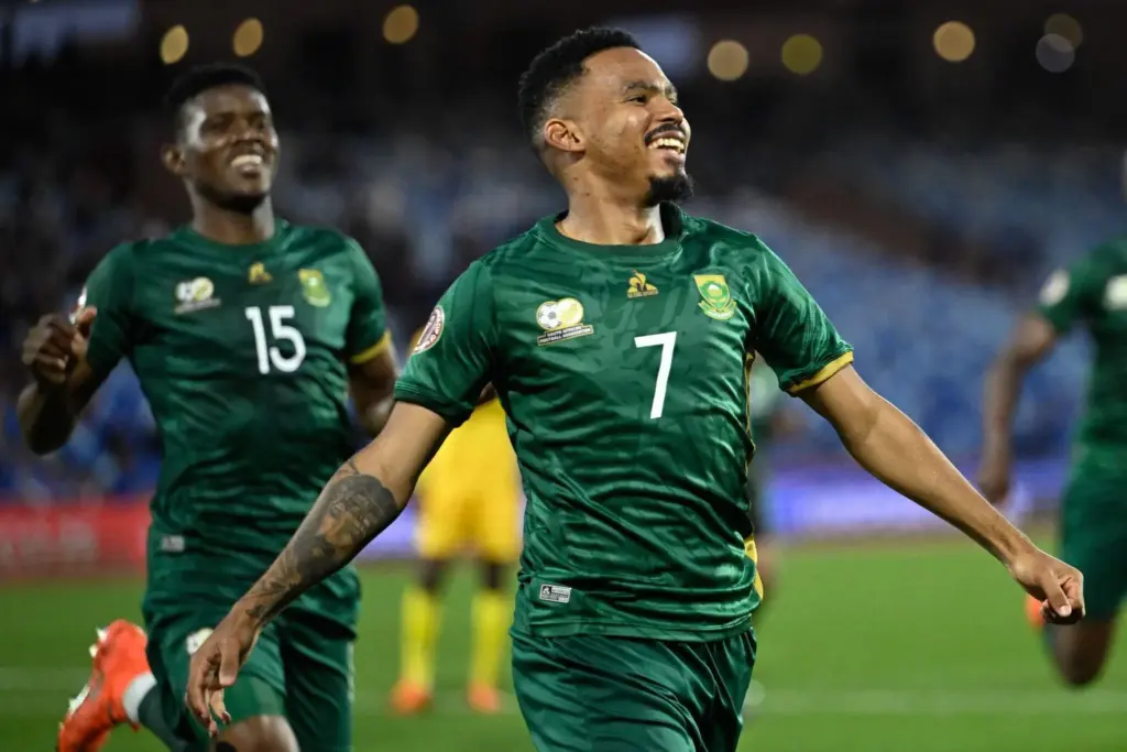 Player celebrating on soccer field wearing green jersey with number 7