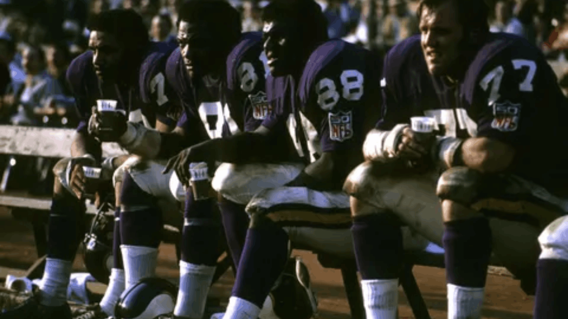 1969 minnesota vikings defensive players sitting together on the sideline during an nfl game