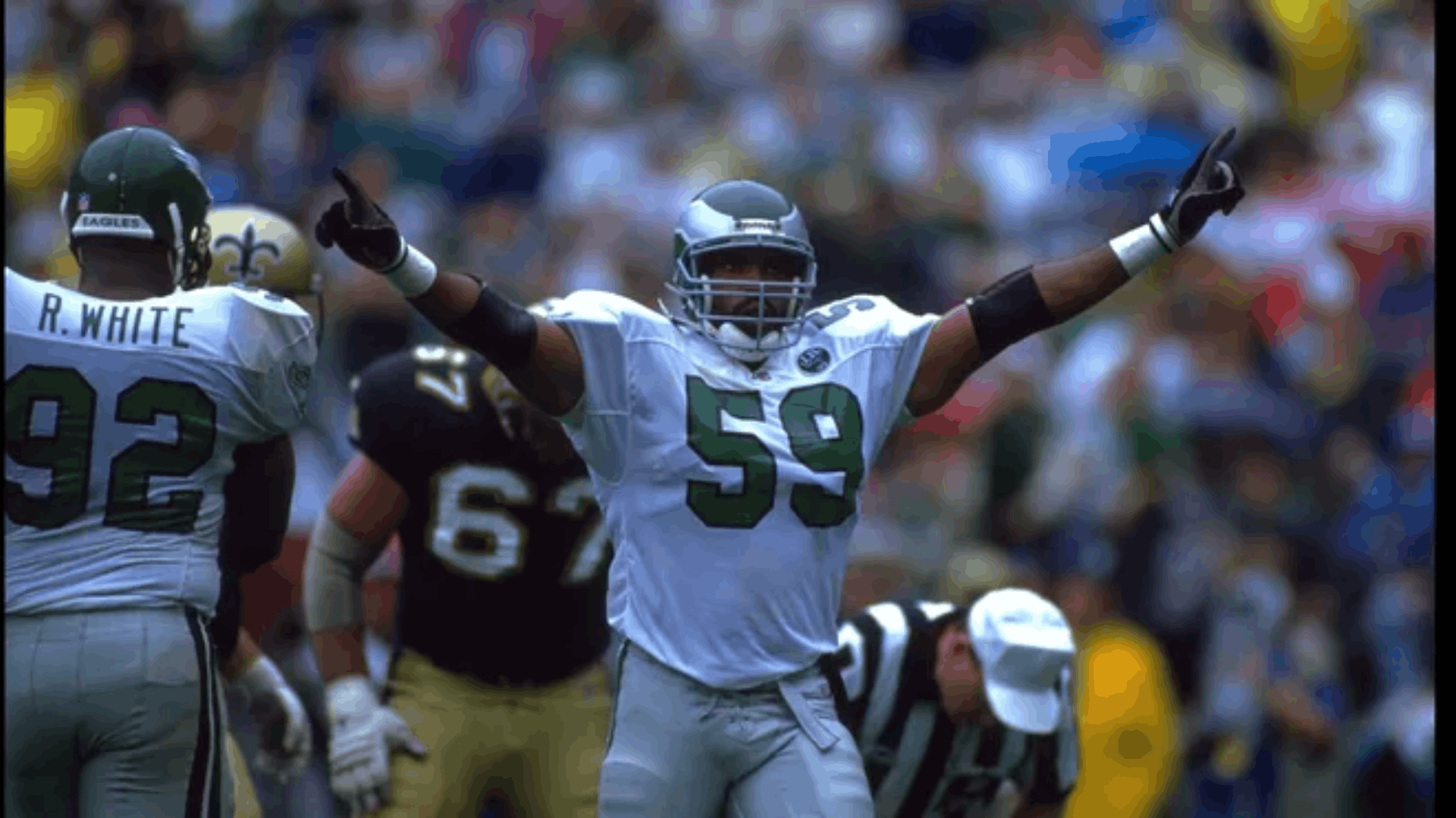 1991 philadelphia eagles defender celebrating on the field during a game as teammates and opposing players stand nearby