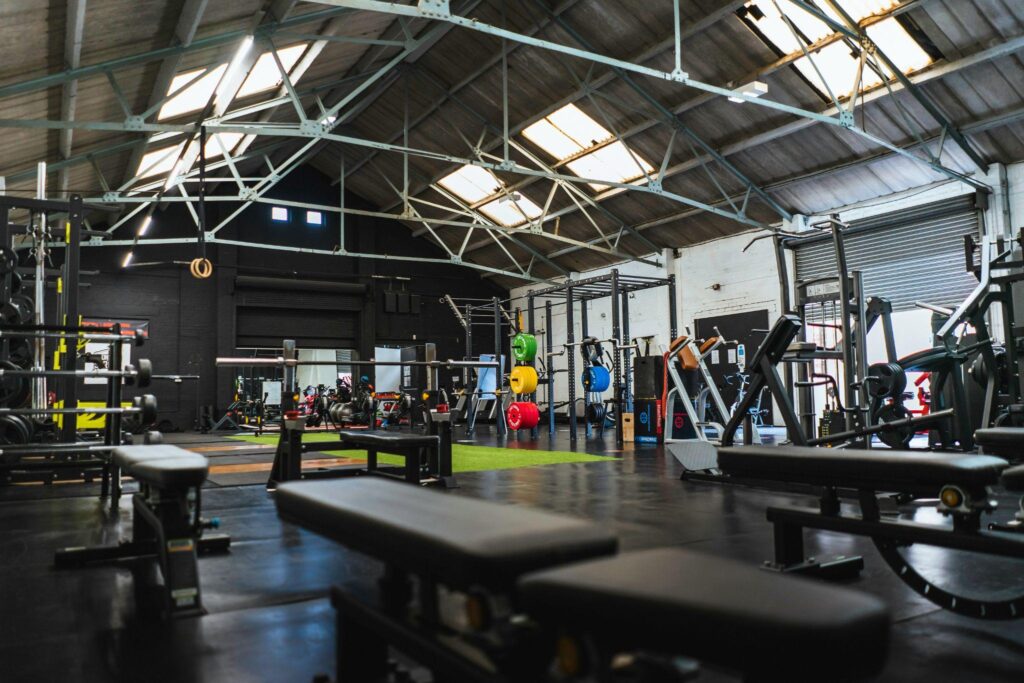 Spacious gym interior with weightlifting equipment and colorful plates under skylights