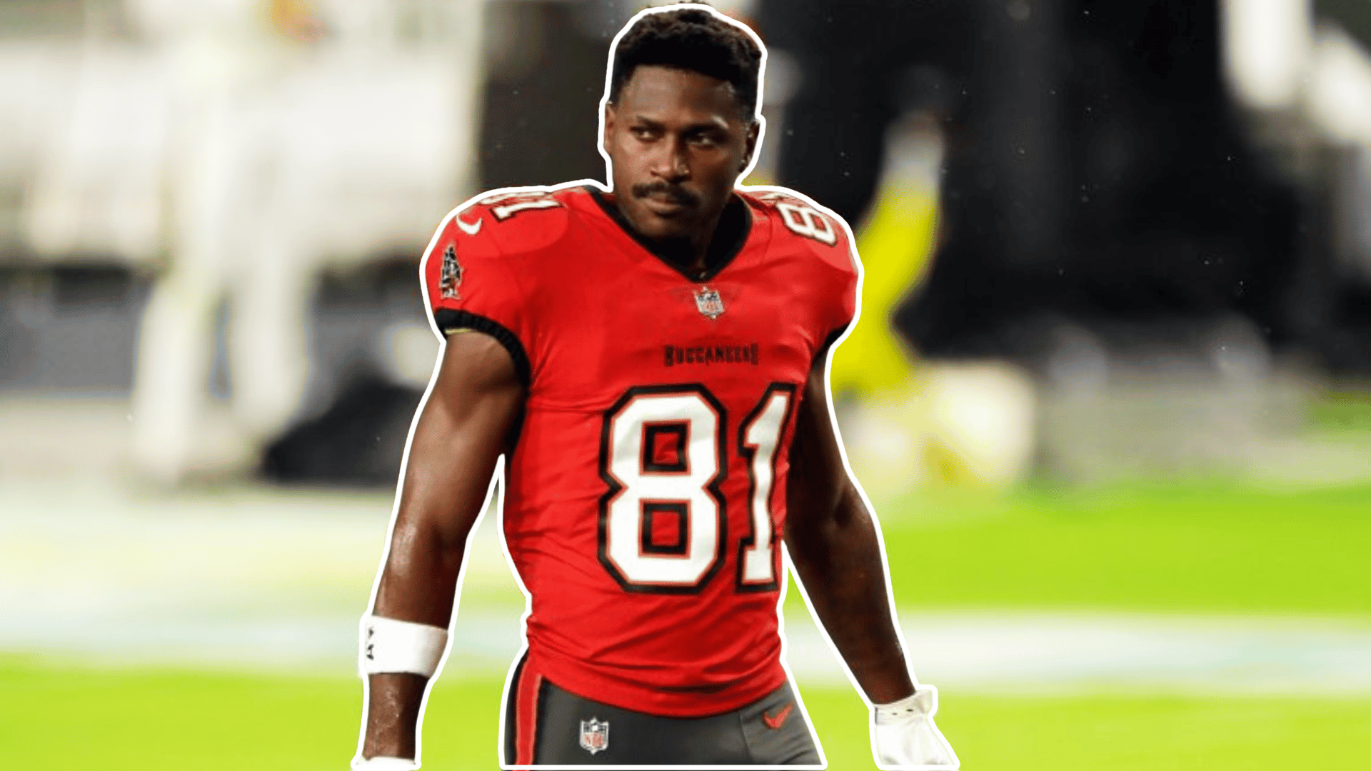 football player wearing a red jersey with number eighty one standing on the field with a blurred stadium behind him