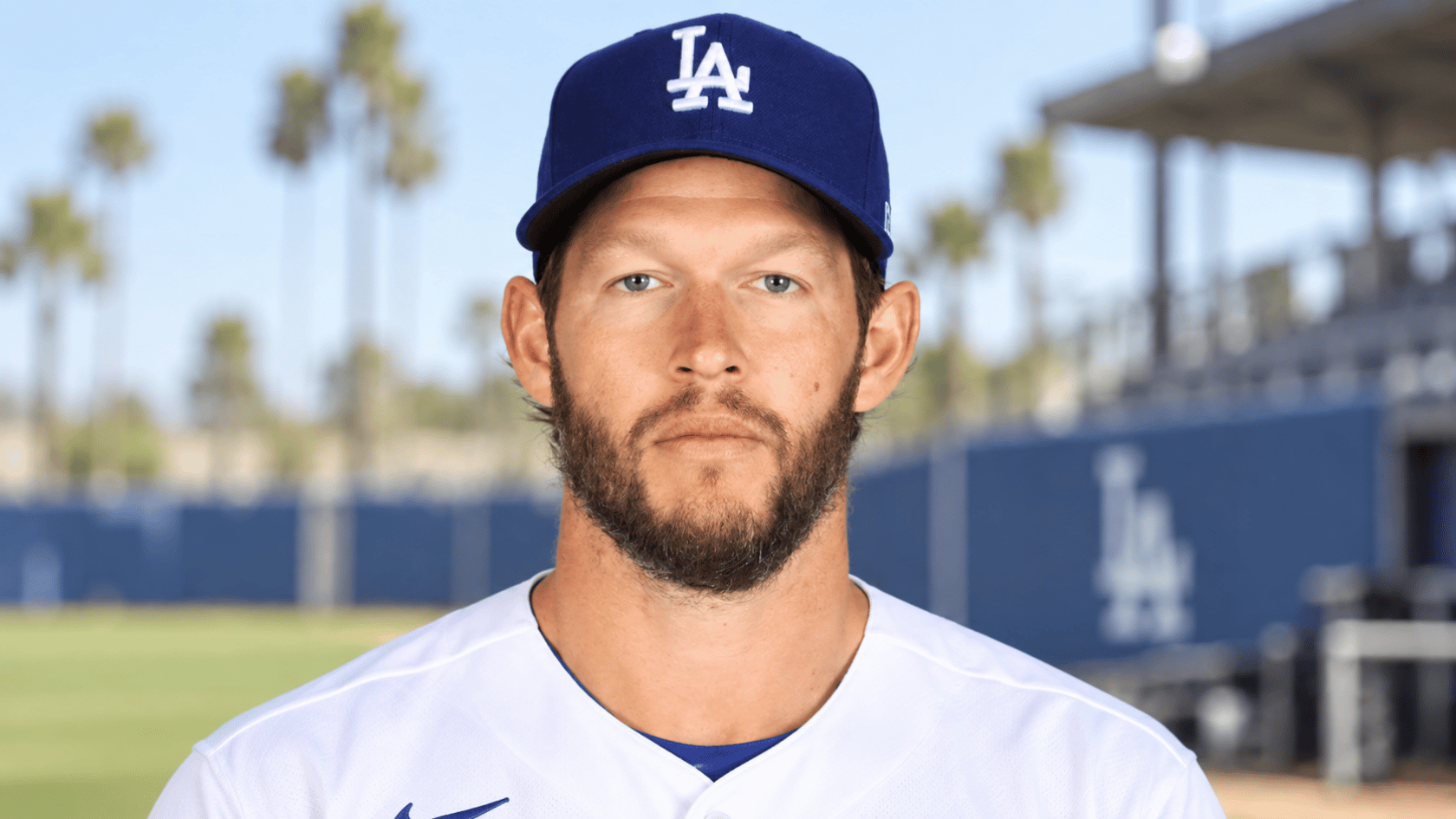 los angeles baseball pitcher wearing a blue team cap and white uniform while standing on the field