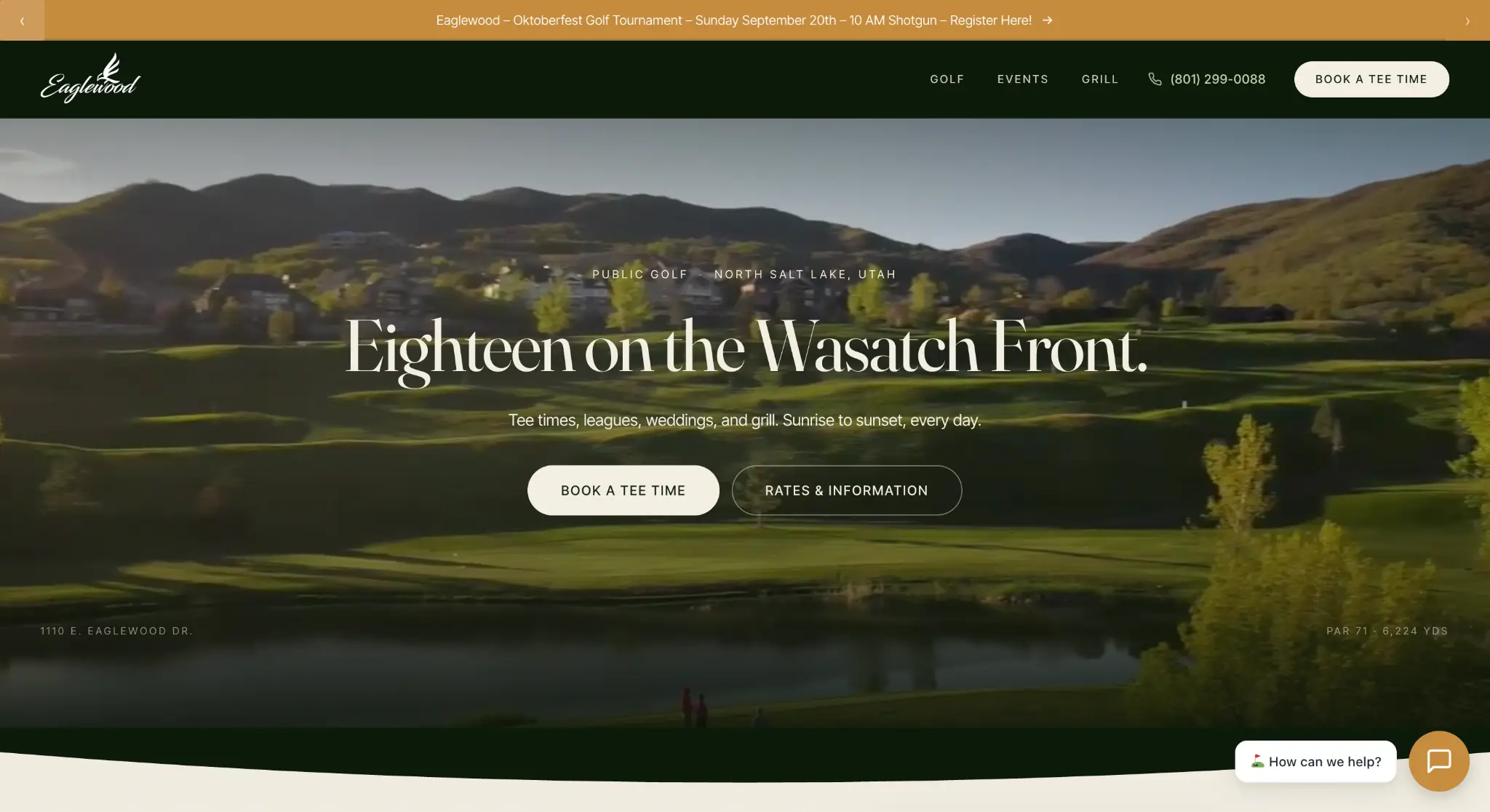 Golf course with rolling hills and trees under clear sky at sunrise