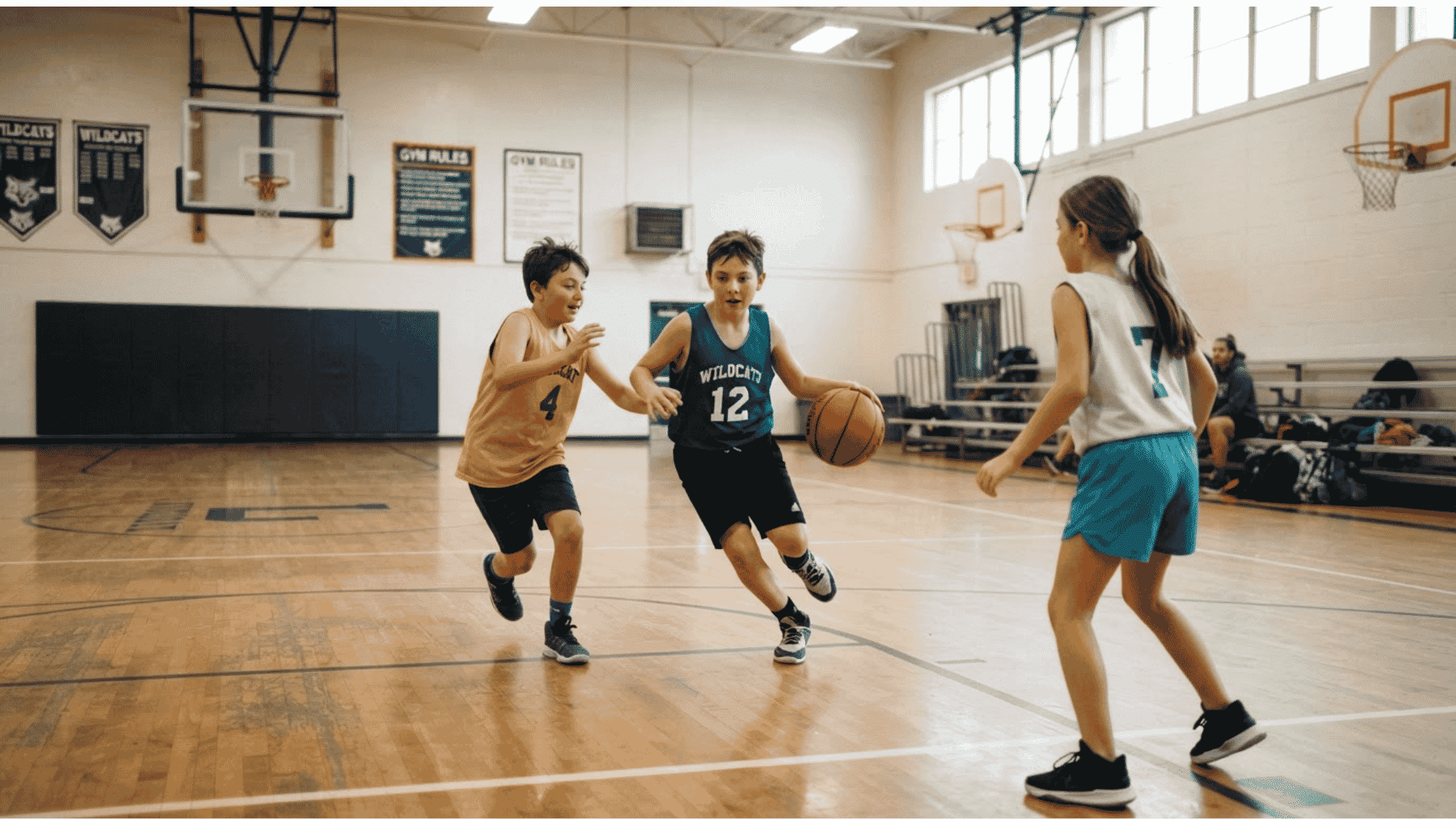 young basketball players practicing a game on indoor court with teammates during a school sports session
