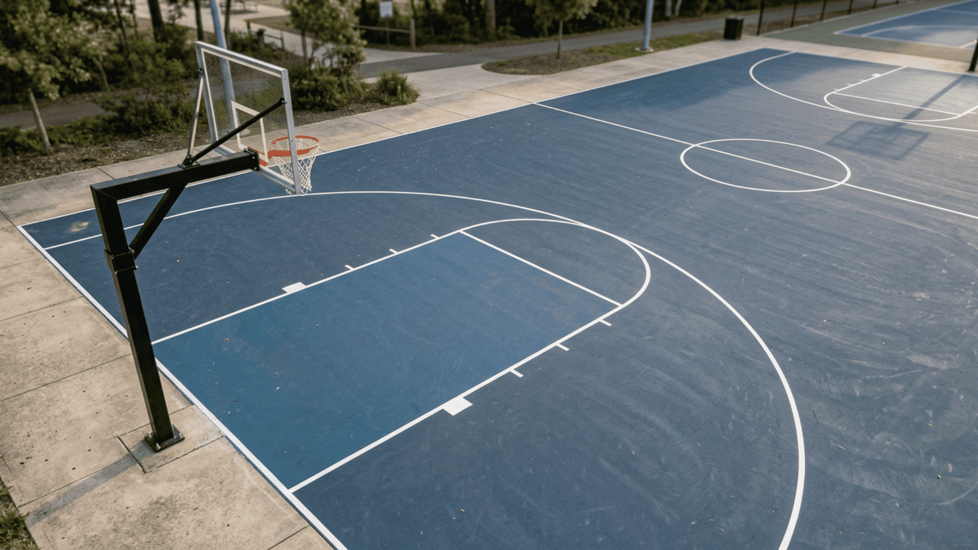 outdoor basketball half court showing the hoop key free throw line and three point arc markings