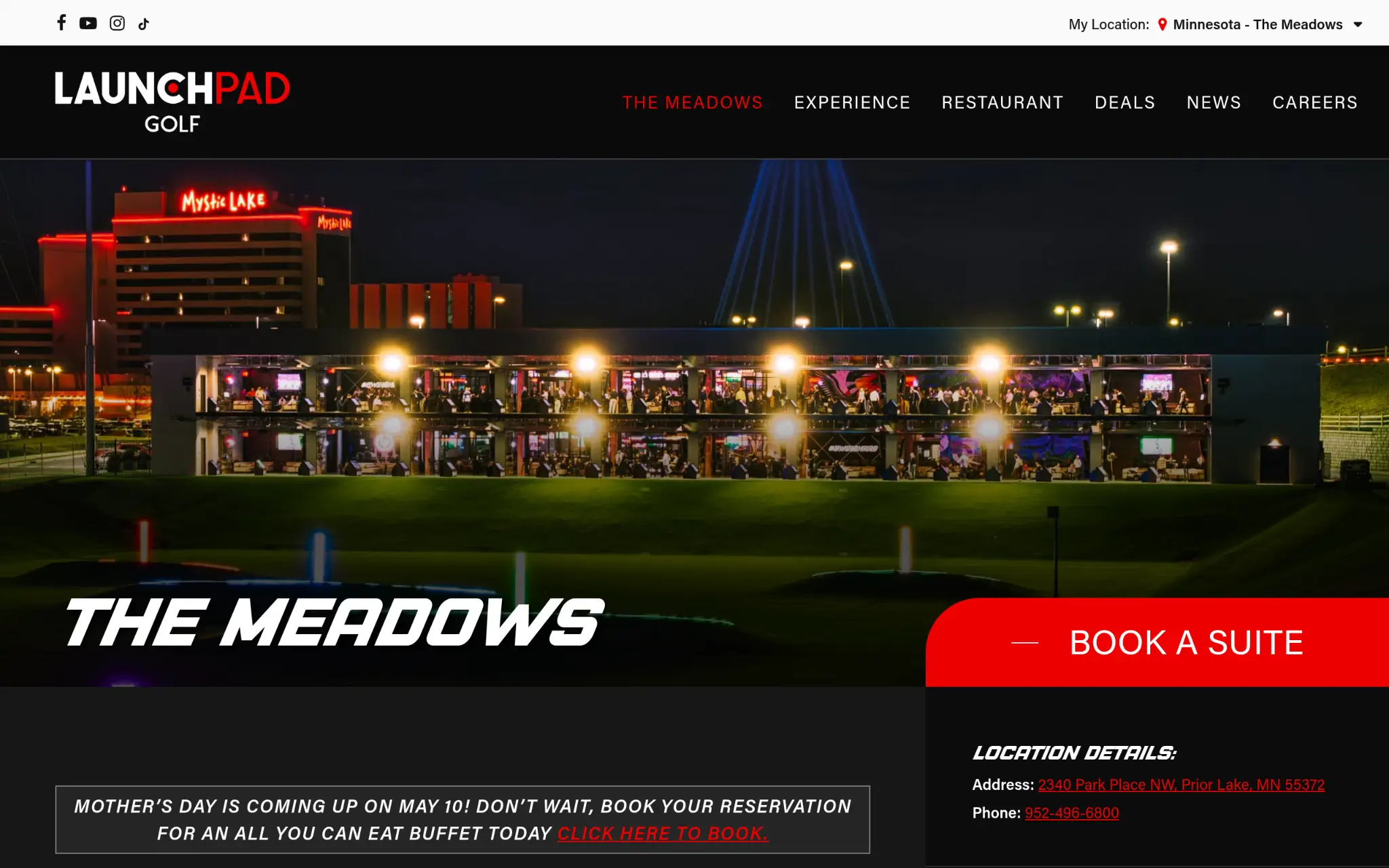 Two-story golfing venue illuminated at night with nearby hotel and bright neon lights