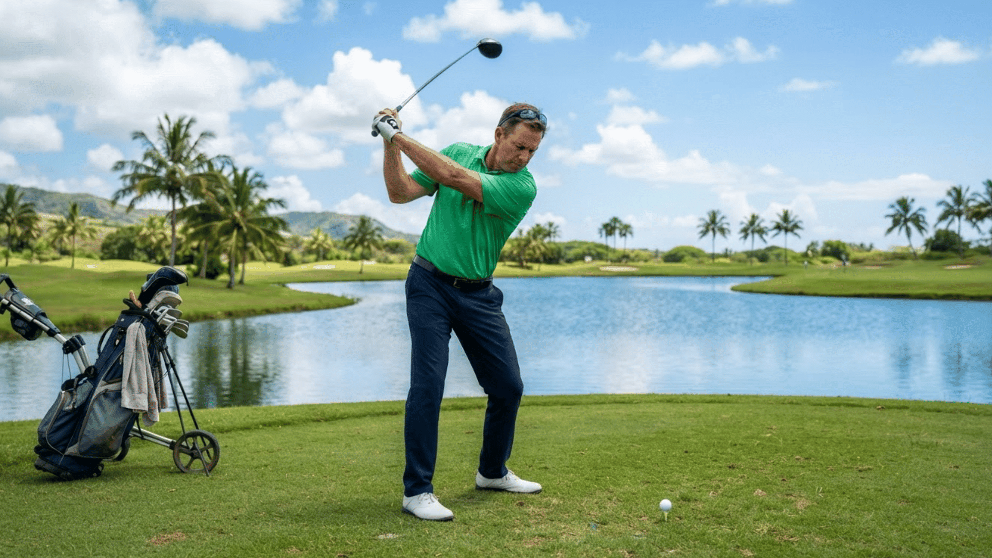 man playing golf on a grassy course while holding a golf club and preparing to take a swing during practice