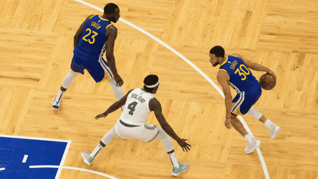 pick and roll basketball play with a ball handler using a screen as a defender guards the action