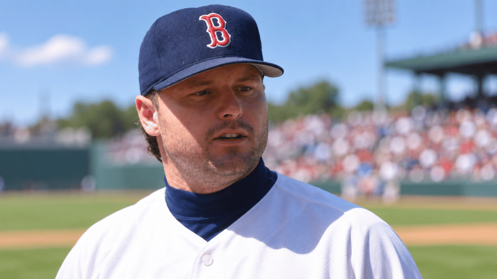 close up portrait of a boston baseball pitcher wearing a navy cap with a red b logo