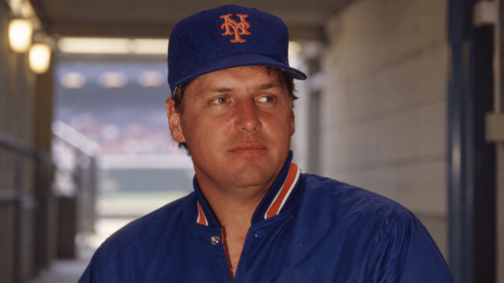 a baseball pitcher wearing a new york cap and team jacket in a close up archival portrait