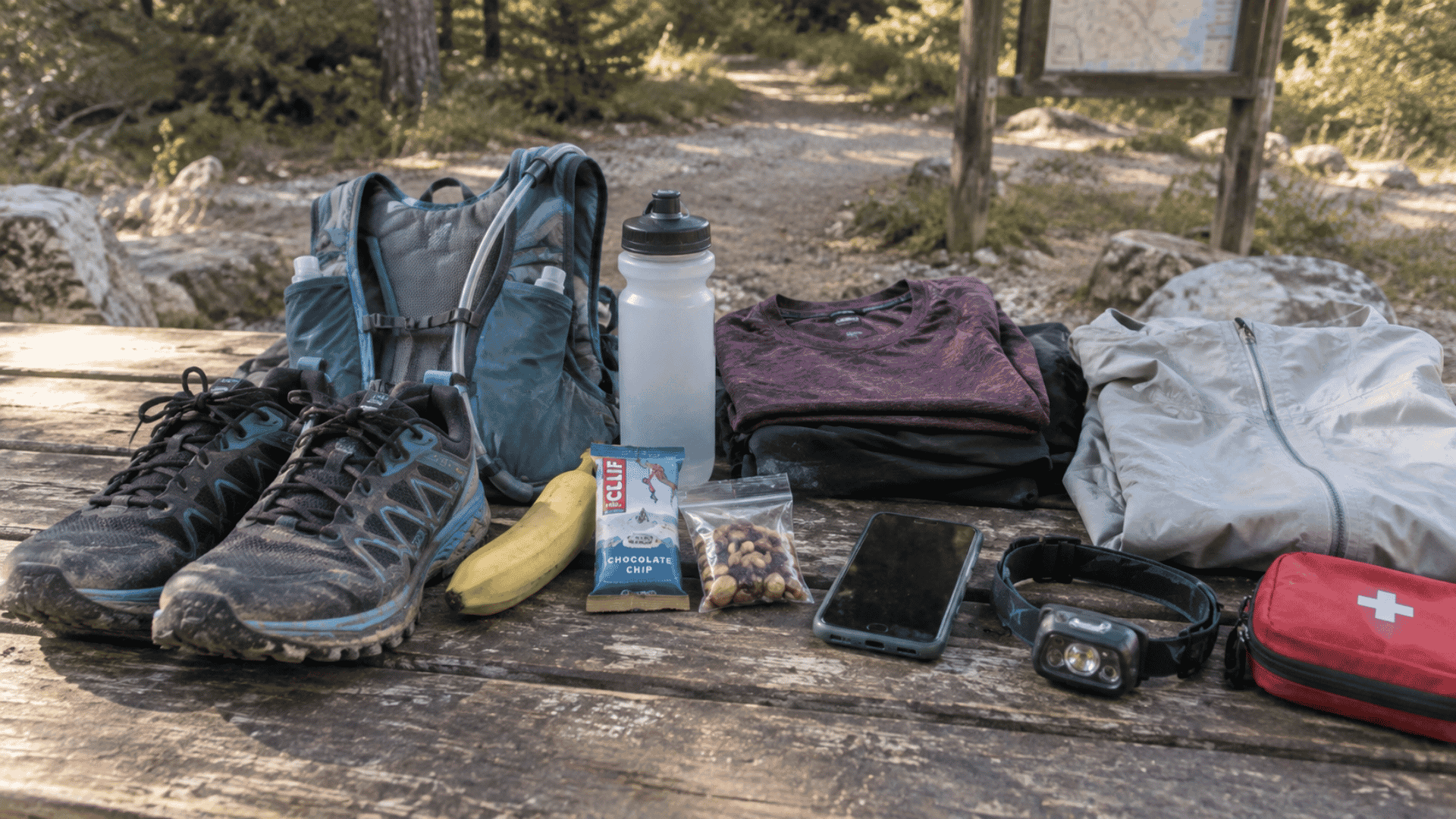 trail running gear including shoes backpack water bottle snacks clothing and first aid supplies