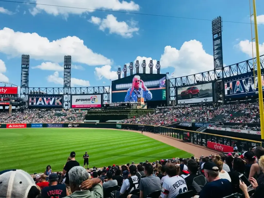 Crowd watching baseball game in large outdoor stadium on sunny day