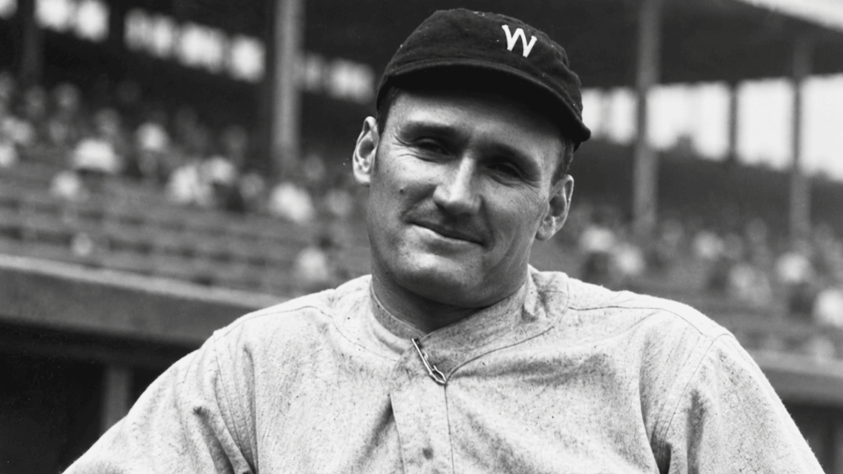 vintage black and white portrait of a baseball pitcher wearing a washington cap and uniform